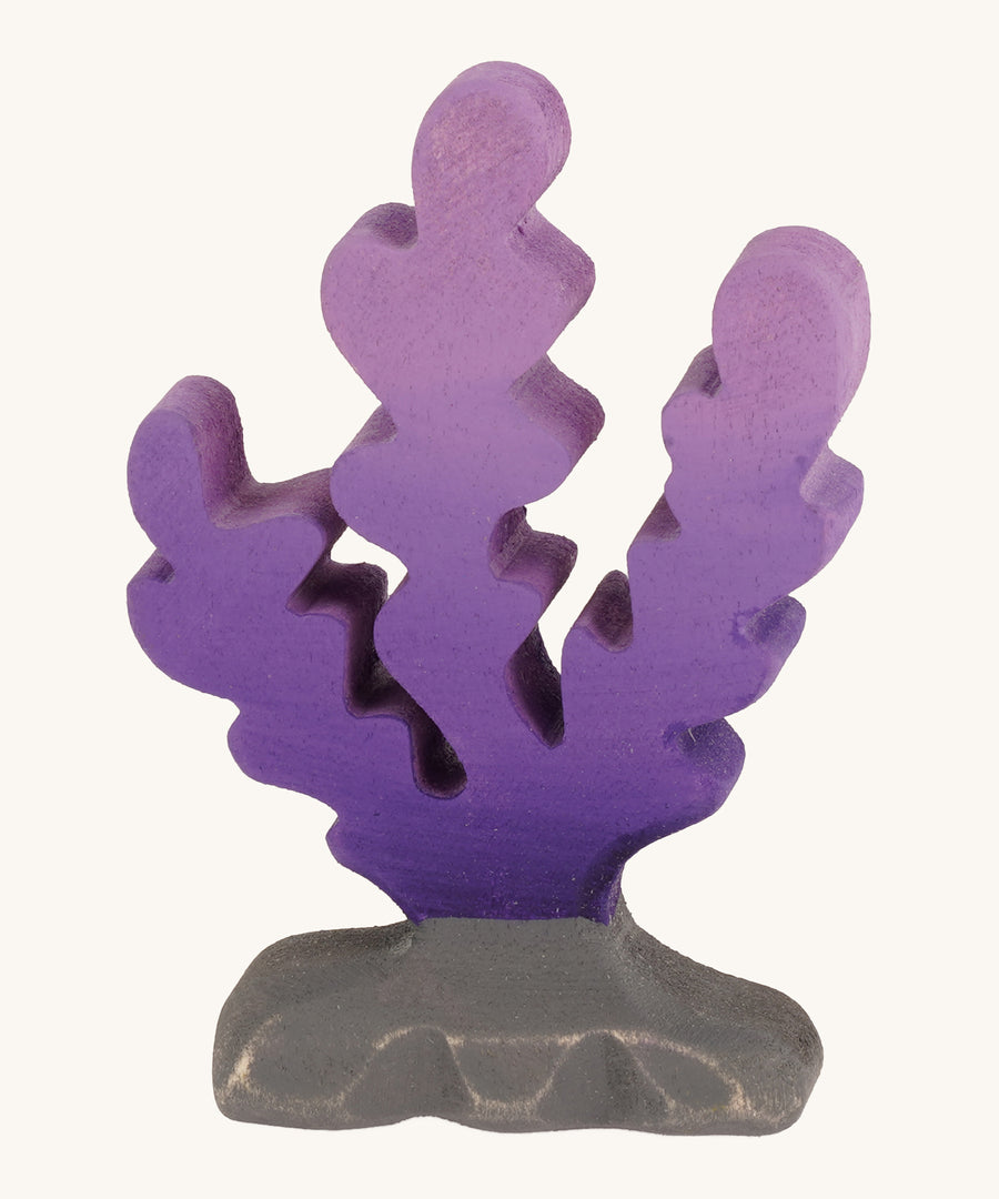 Bumbu wooden purple seaweed figure on a plain background.