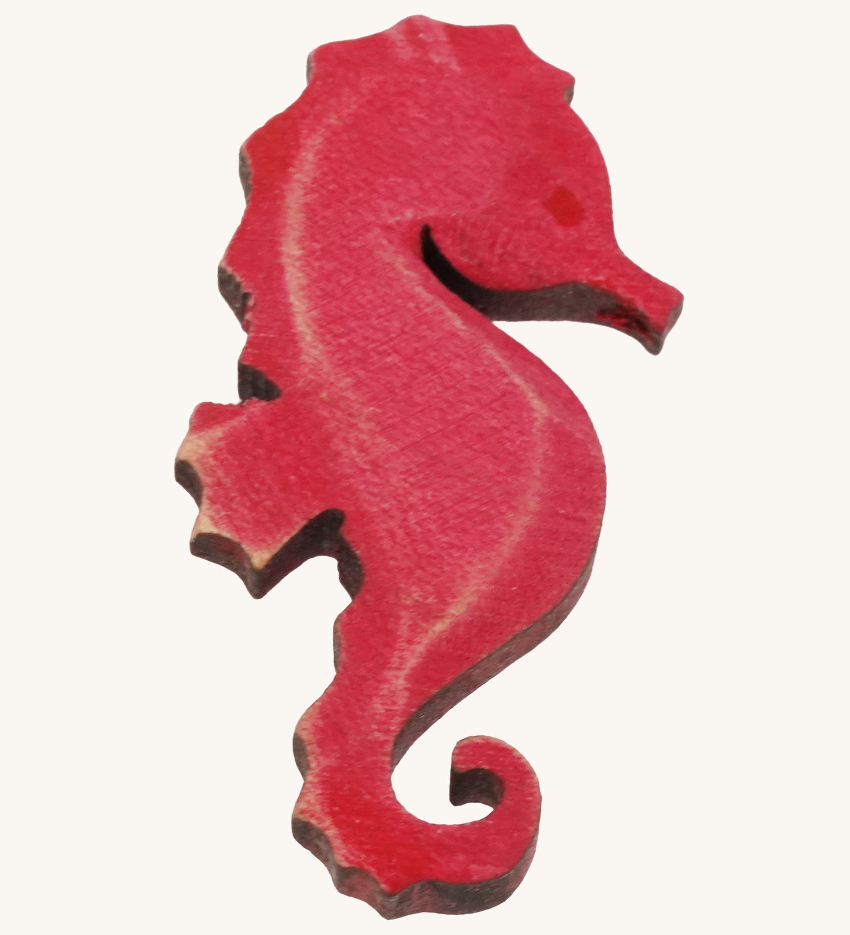 Bumbu pink wooden seahorse figure on a plain background.