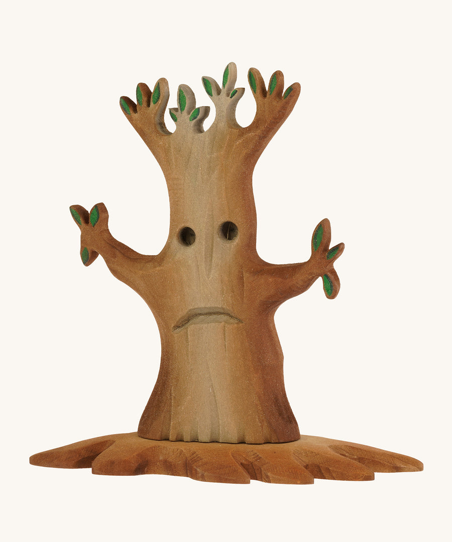 Bumbu wooden spooky tree with facial features on the trunkon a plain background