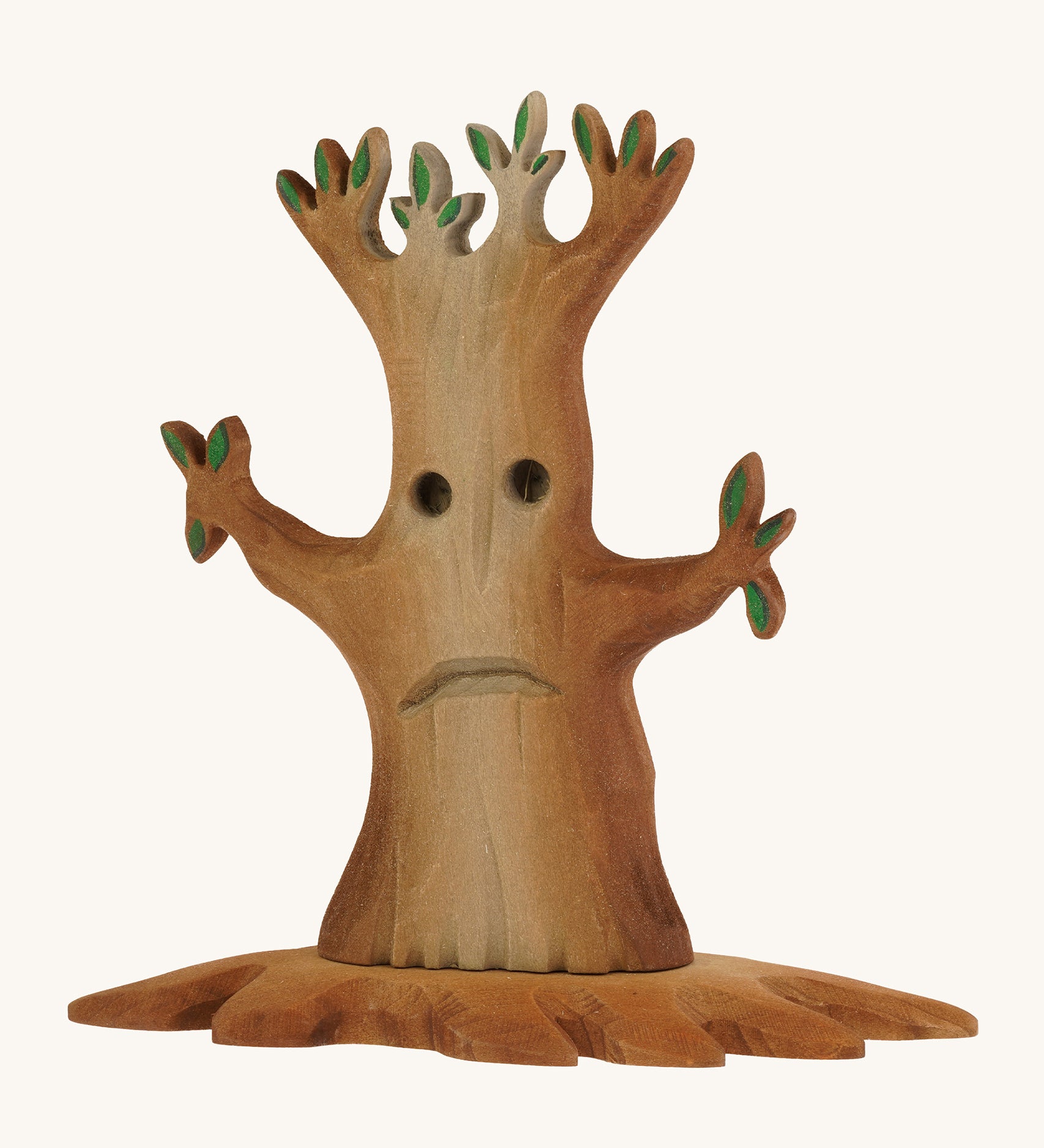 Bumbu wooden spooky tree with facial features on the trunkon a plain background