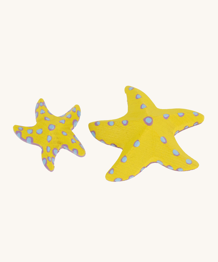 Bumbu yellow wooden starfish set on a plain background. 