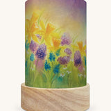 The Burst Of Spring illustration by Baukje Exler sat in a Toverlux Magic Lantern base, on a cream background