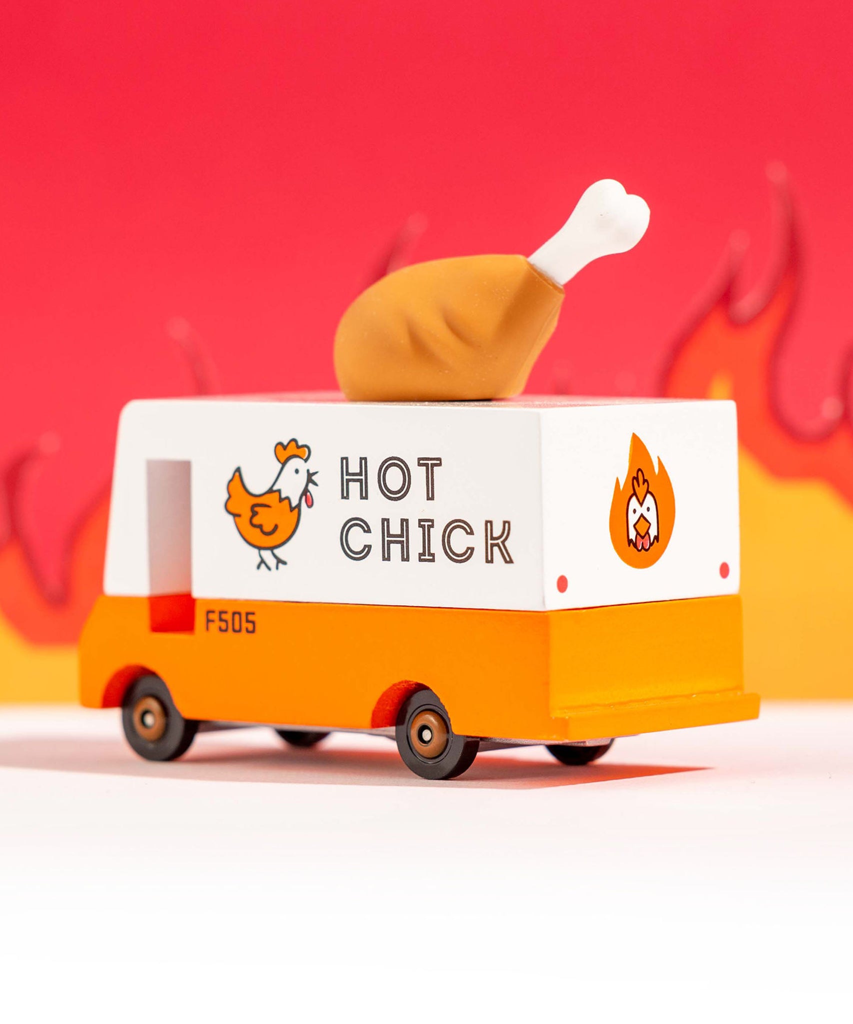 The The Candylab Candyvan - Fried Chicken Van from the back and side,  on a red fiery background