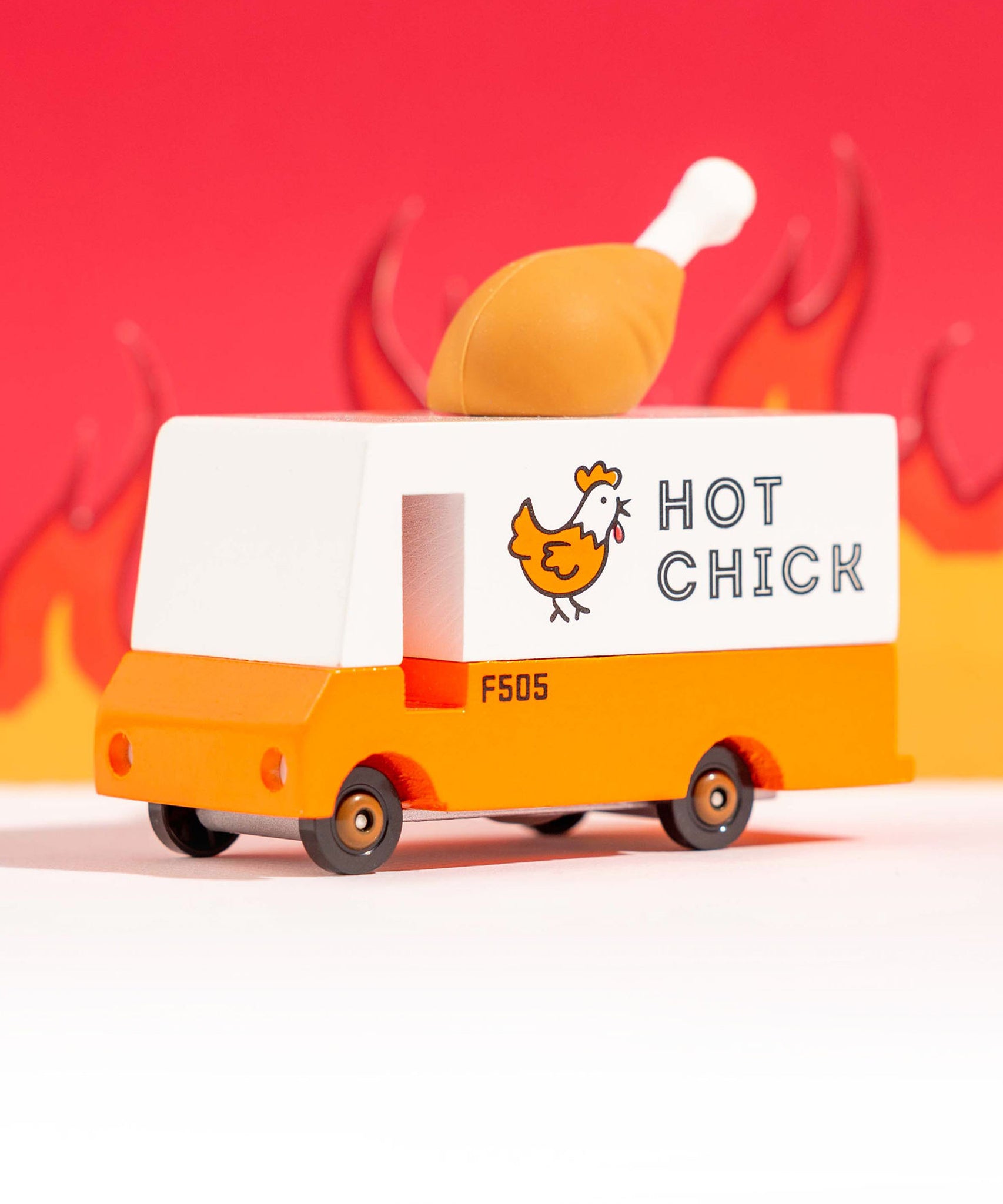 The The Candylab Candyvan - Fried Chicken Van from a side angle on a red fiery background