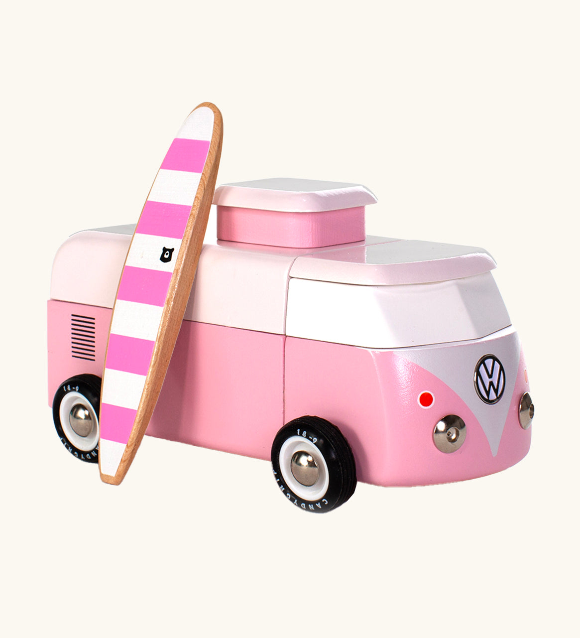 The Candylab VW Beach bus in pink, with a wooden pink and white stripe surf board propped up next to the van, The image is on a cream background