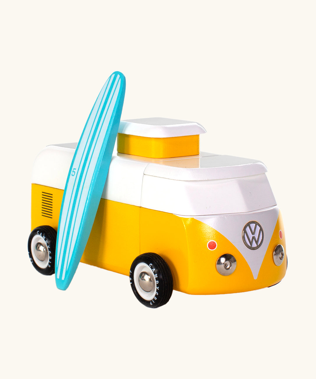 The Candylab VW Beach bus in yellow, with a wooden blue and white stripe surf board propped up next to the van, The image is on a cream background