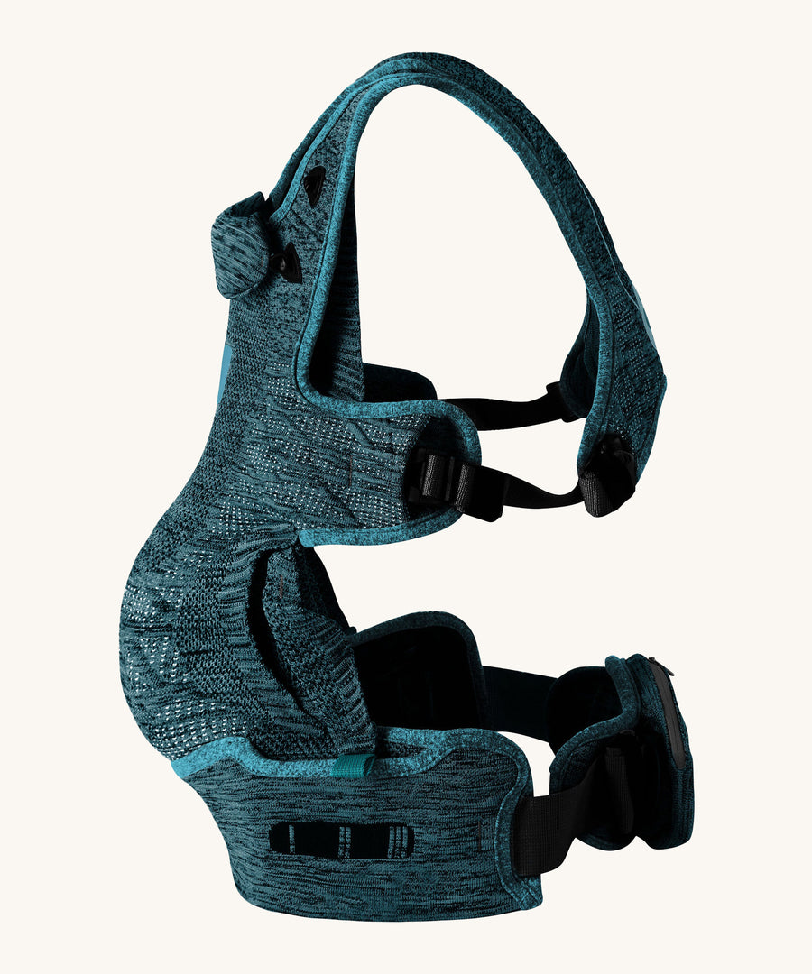 The Carifit+ Baby Carrier in Cool Green from the side showing the adjustable adaptive straps on the side and waist, on a cream background