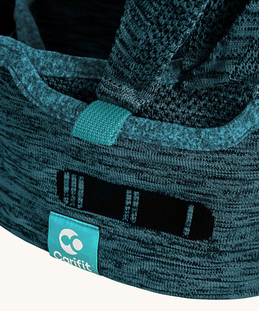 A closer look at the waist strap of the Carifit+ Baby Carrier in Cool Green showing the fabric details