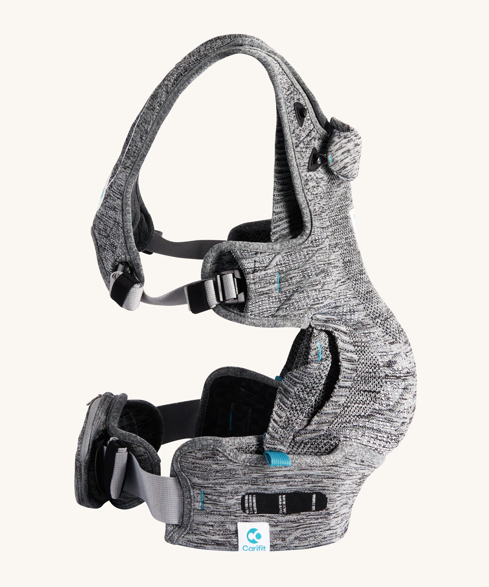 The Carifit+ Baby Carrier in Cool Grey from the side showing the adjustable adaptive straps on the side and waist, on a cream background