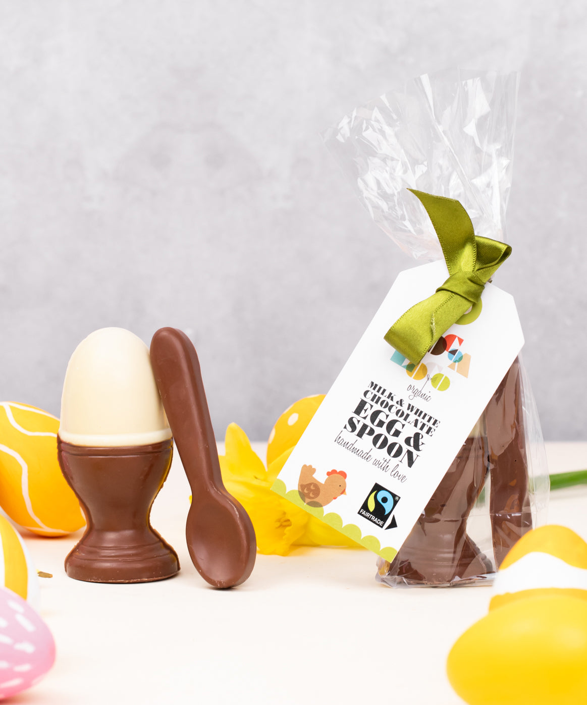 Cocoa Loco Fairtrade organic Easter chocolate set in biodegradable packaging. Solid white chocolate egg in a milk chocolate eggcup with a spoon, shaped like a boiled egg. Handmade in the UK.