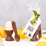 Cocoa Loco Fairtrade organic Easter chocolate set in biodegradable packaging. Solid white chocolate egg in a milk chocolate eggcup with a spoon, shaped like a boiled egg. Handmade in the UK.