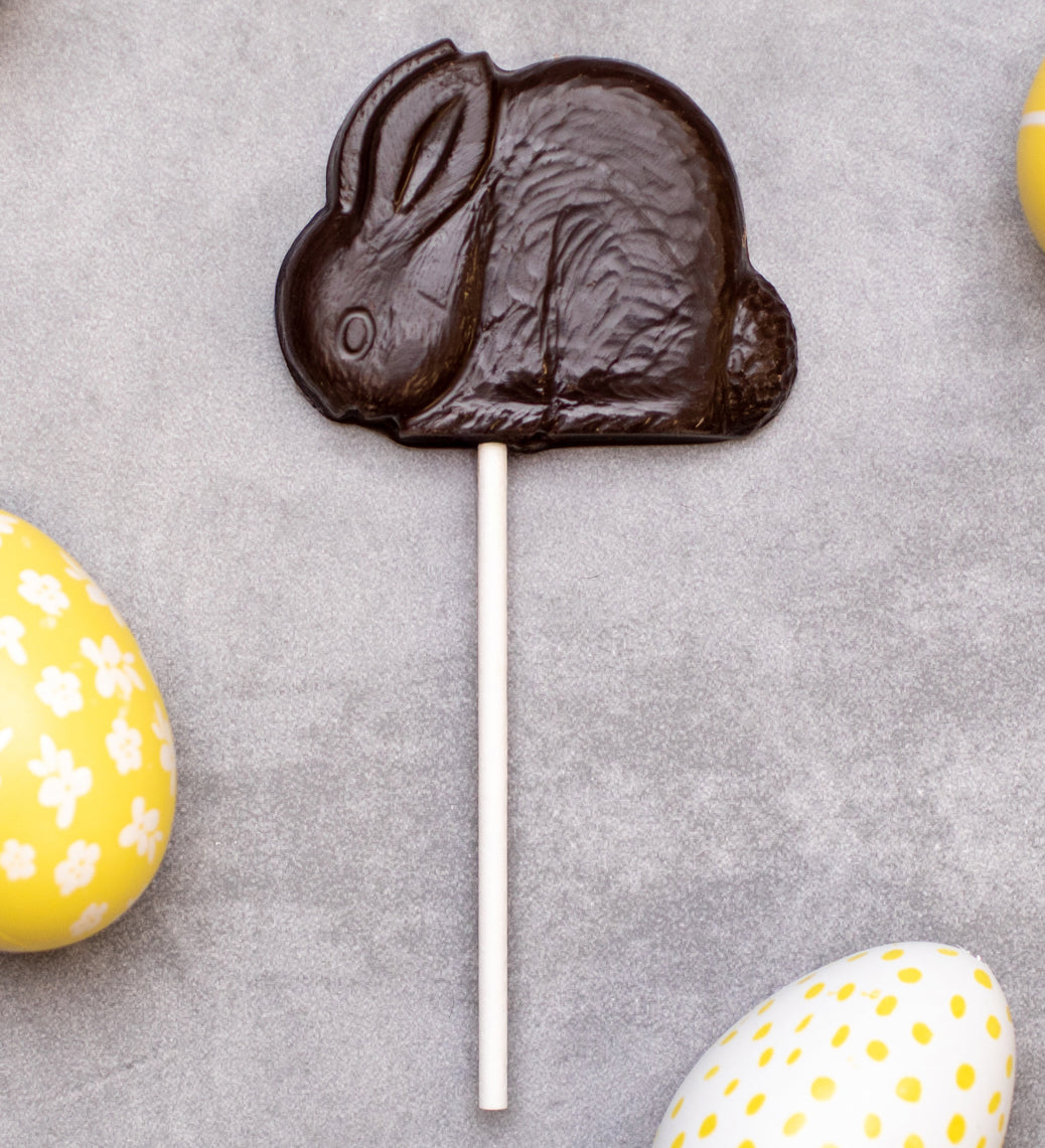 Cocoa Loco organic Fairtrade vegan dark chocolate shaped rabbit lolly. Surrounded by colourful mini easter eggs.