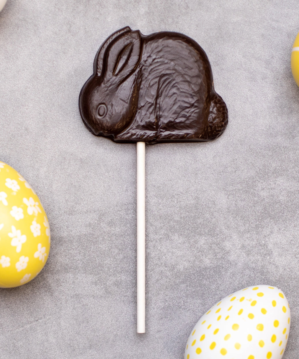 Cocoa Loco organic Fairtrade vegan dark chocolate shaped rabbit lolly. Surrounded by colourful mini easter eggs.