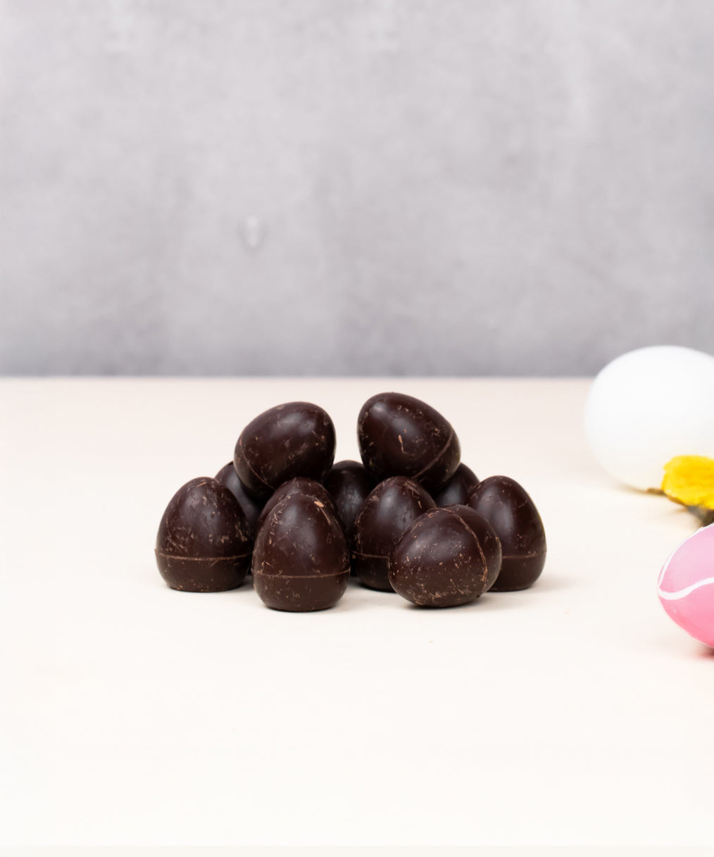 Cocoa Loco organic Fairtrade vegan mini dark chocolate eggs. Small easter eggs are in frame to add a decorative springtime feel.