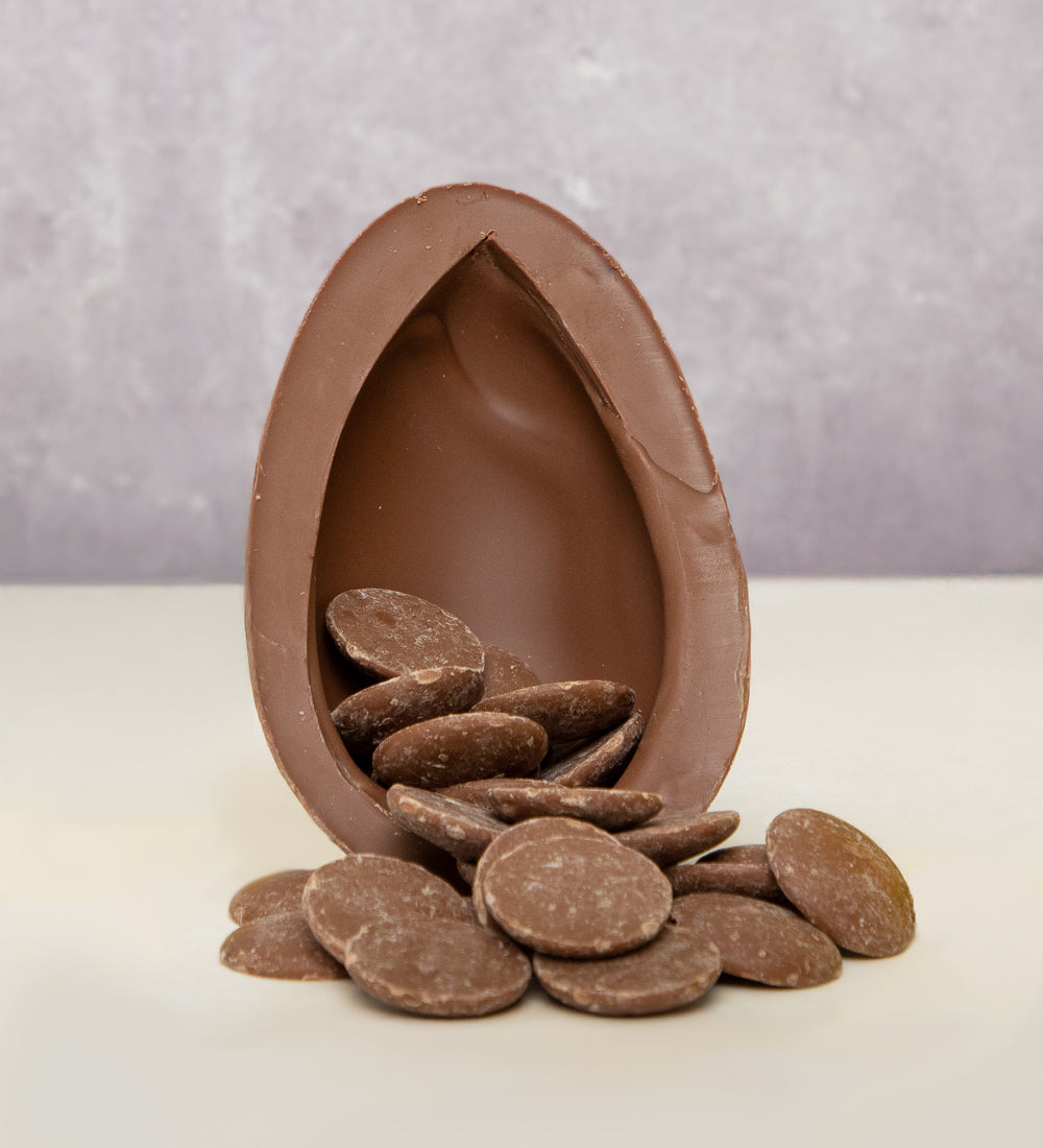 Cocoa Loco Fairtrade organic milk chocolate Easter egg, halved to reveal a cascade of chocolate buttons. 
