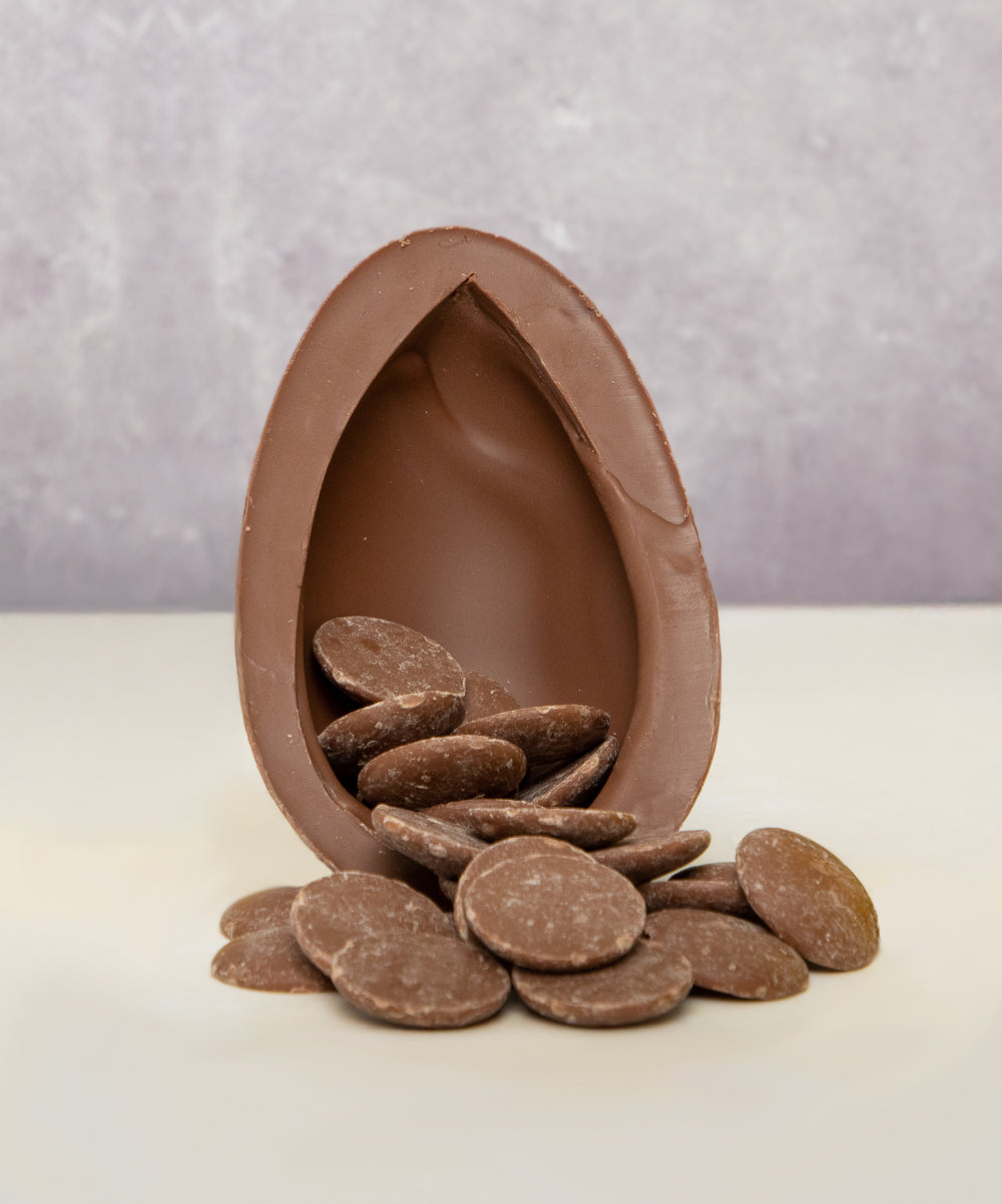 Cocoa Loco Fairtrade organic milk chocolate Easter egg, halved to reveal a cascade of chocolate buttons. 
