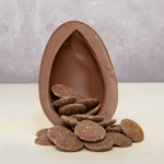 Cocoa Loco Fairtrade organic milk chocolate Easter egg, halved to reveal a cascade of chocolate buttons. 
