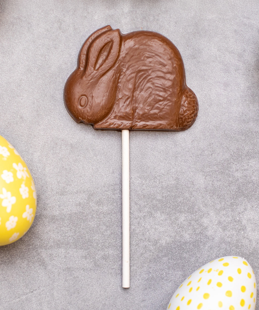 Cocoa Loco organic Fairtrade milk chocolate shaped rabbit lolly. Surrounded by colourful mini easter eggs.