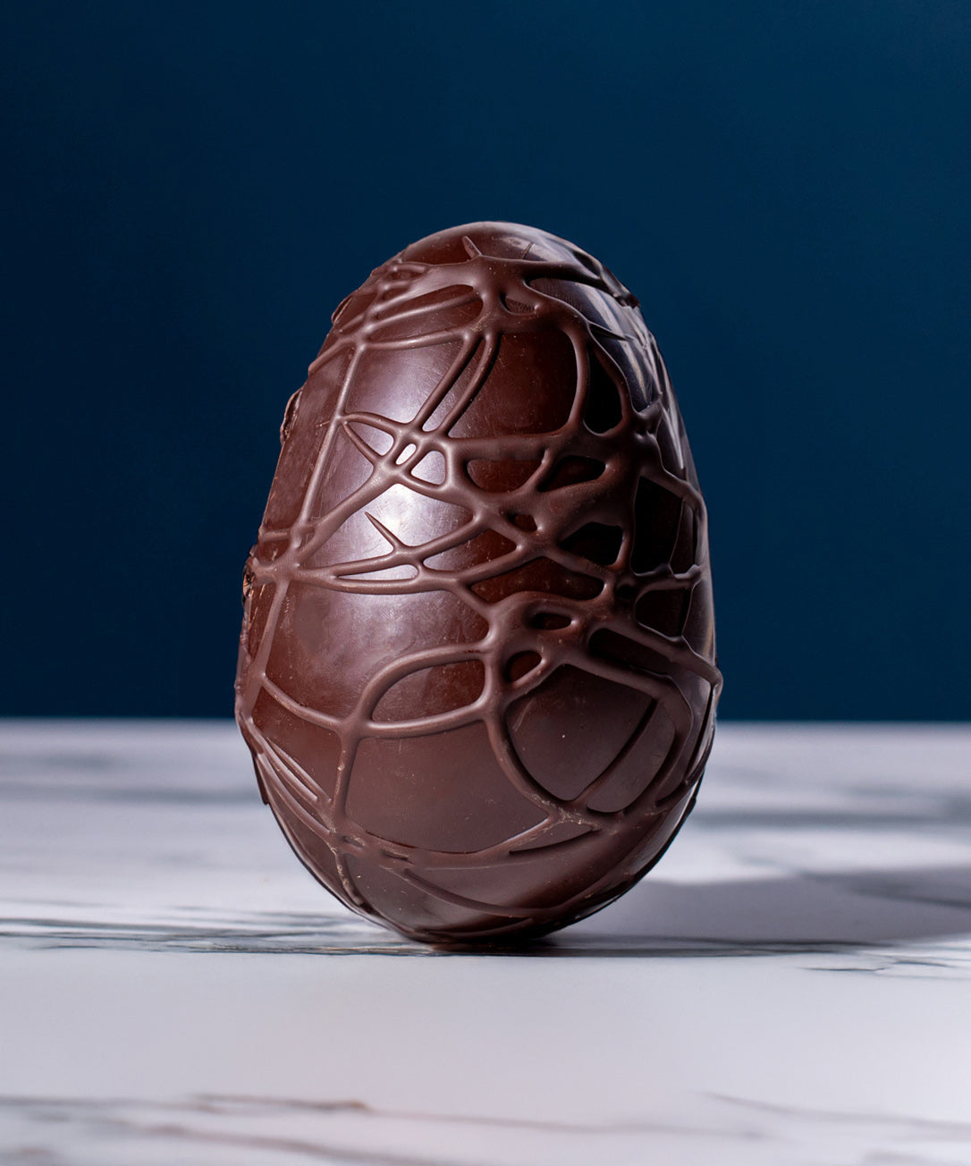 Cocoa Loco Fairtrade organic vegan dark chocolate Easter egg, hand decorated with intricate chocolate swirls.