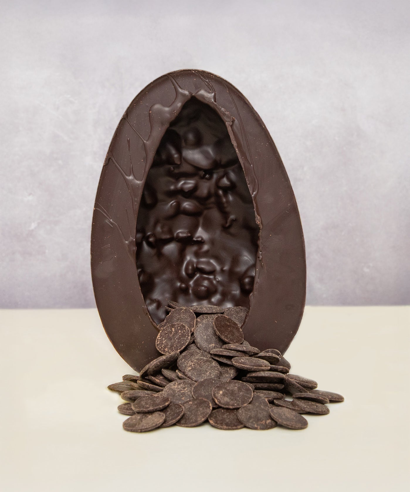 Cocoa Loco oragnic Fairtrade vegan dark chocolate easter egg, halved to reveal a cascade of dark chocolate buttons.