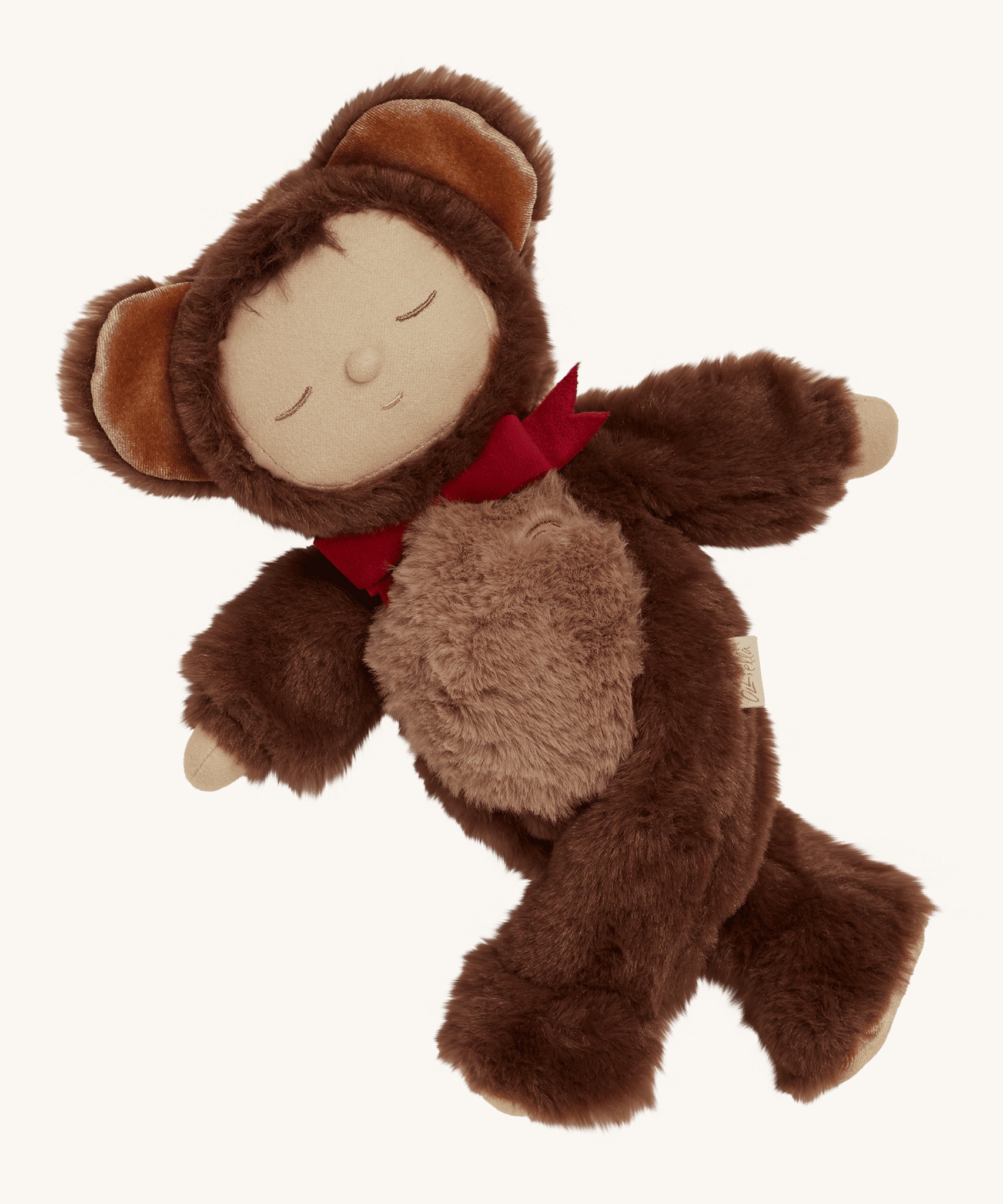 Olli Ella Cozy Dinkums - Teddy Twiggy with its arms wide open and its legs crossed, showing how the arms and legs of the doll can move with ease, on a cream background. Teddy Twiggy has a warm, smiling, sleeping face, a cute button nose and a patch of dark brown hear poking out from underneath its hood.