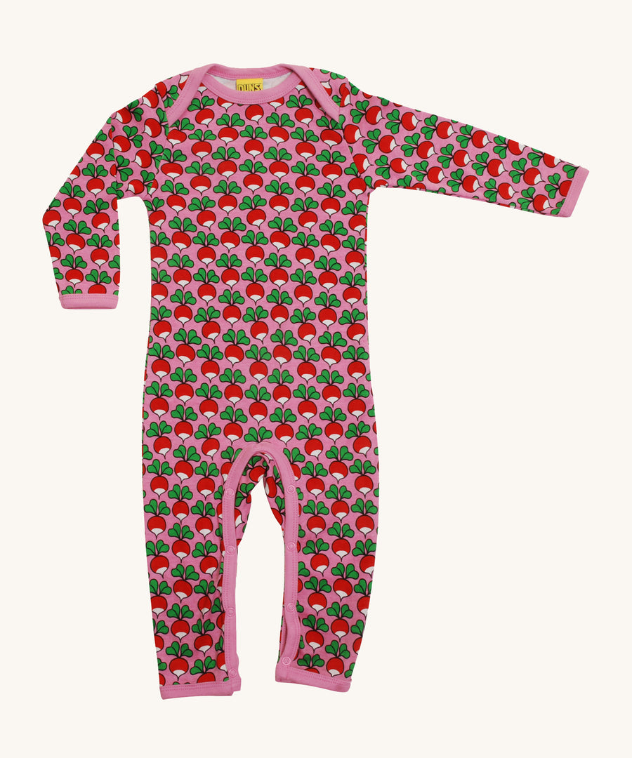 A soft, organic cotton, long sleeve bodysuit. With a repeat radish print pattern and pink piping and poppers on the inside of the legs