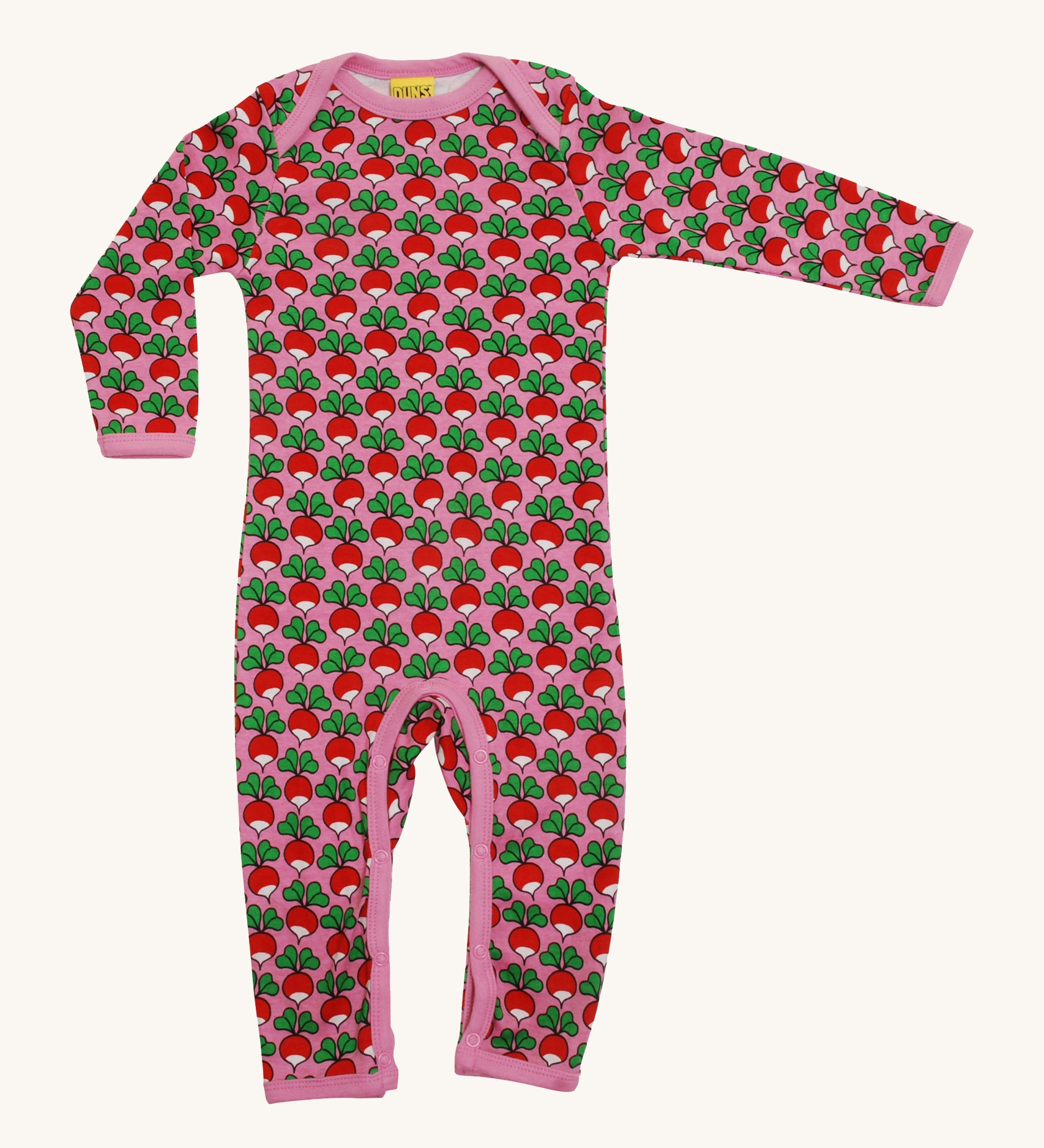 A soft, organic cotton, long sleeve bodysuit. With a repeat radish print pattern and pink piping and poppers on the inside of the legs