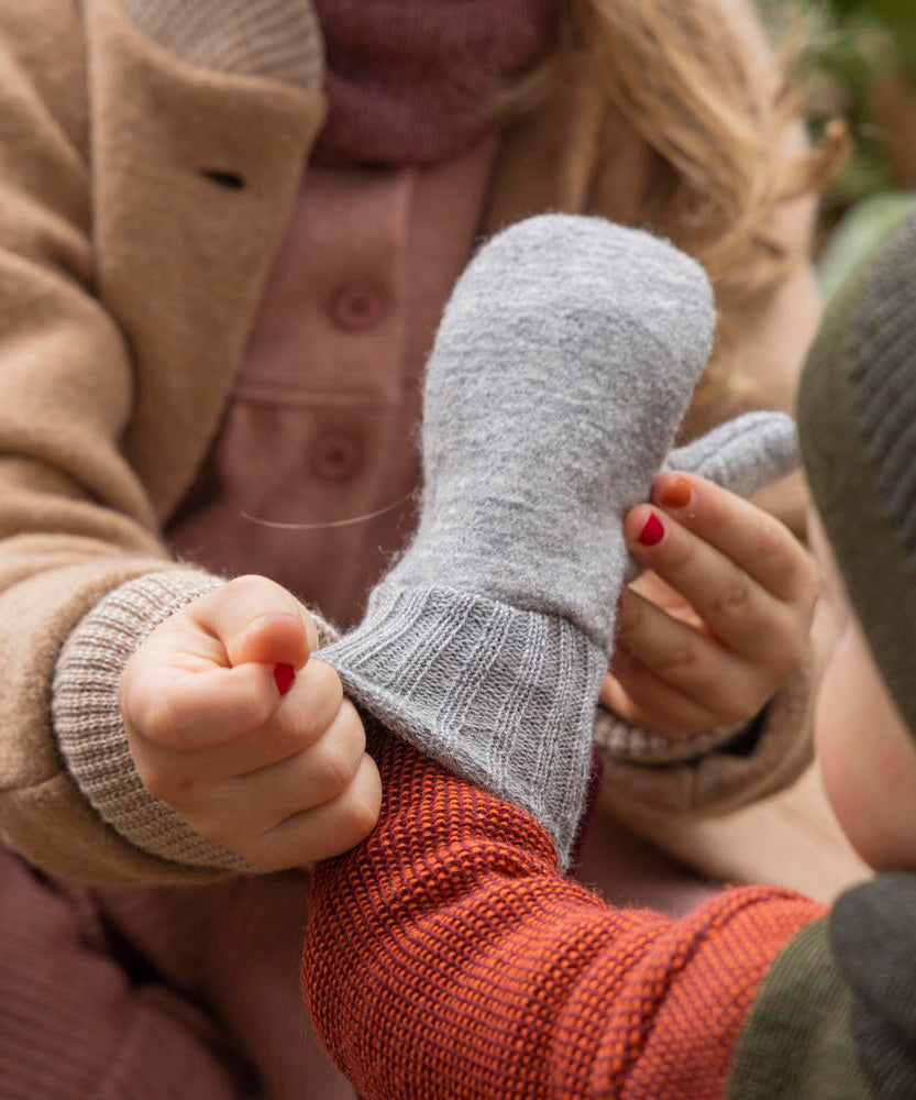 Disana merino wool grey mitten worn by a baby cuff detail