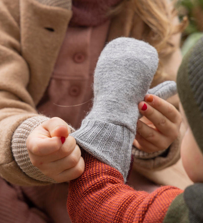 Disana merino wool grey mitten worn by a baby cuff detail