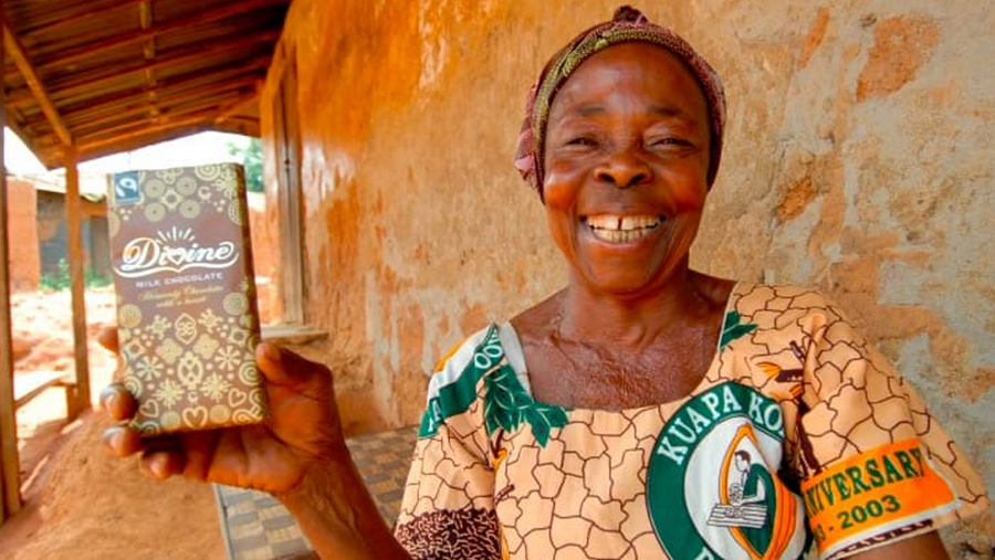 Chocolate farmer holding up a bar of Divine Chocolate