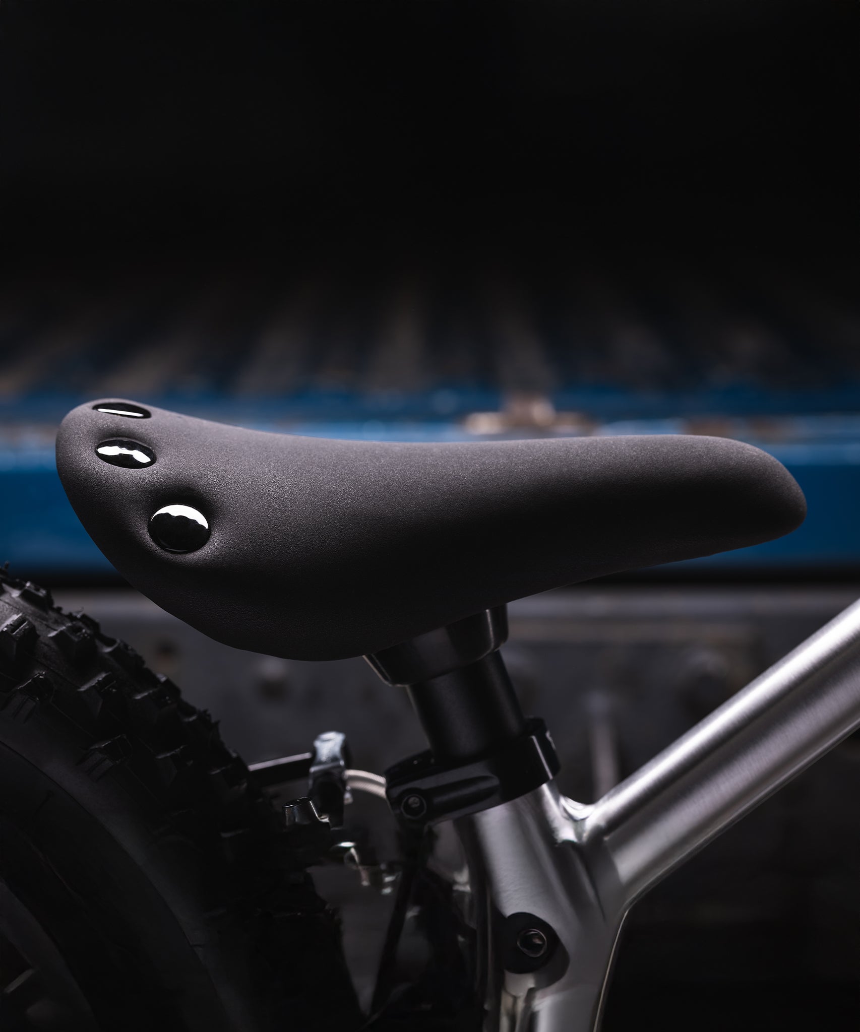 A closer look at the adjustable seat on the Early Rider Big Foot Balance Bike. It is a black seat with flat, black studs on the back of the seat