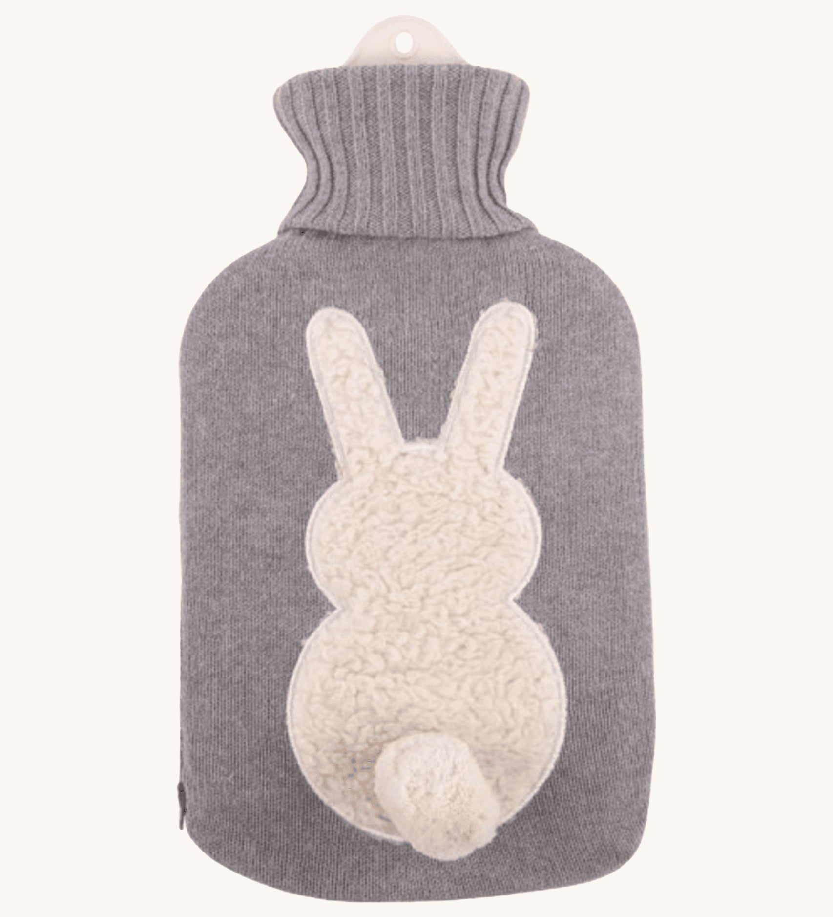 The Ecoliving Natural Rubber Hot Water Bottle - Bunny, has a soft grey knitted cotton cover with a fluffy white bunny silhouette and a cute white cotton tail. The image is on a cream background