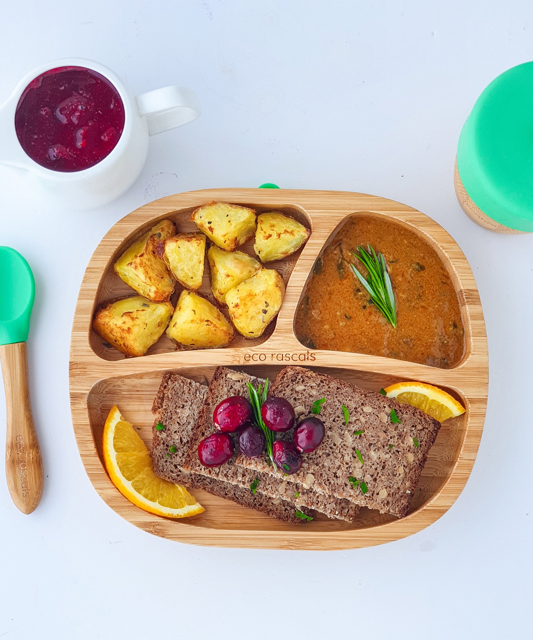 Bamboo baby section plate with roast potatoes, gravy and rye bread slices.