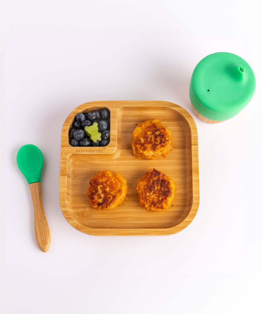 A top view of the Eco Rascals Natural Bamboo Square Plate, between an Eco Rascals Sippy Cup and Eco Rascals Spoon