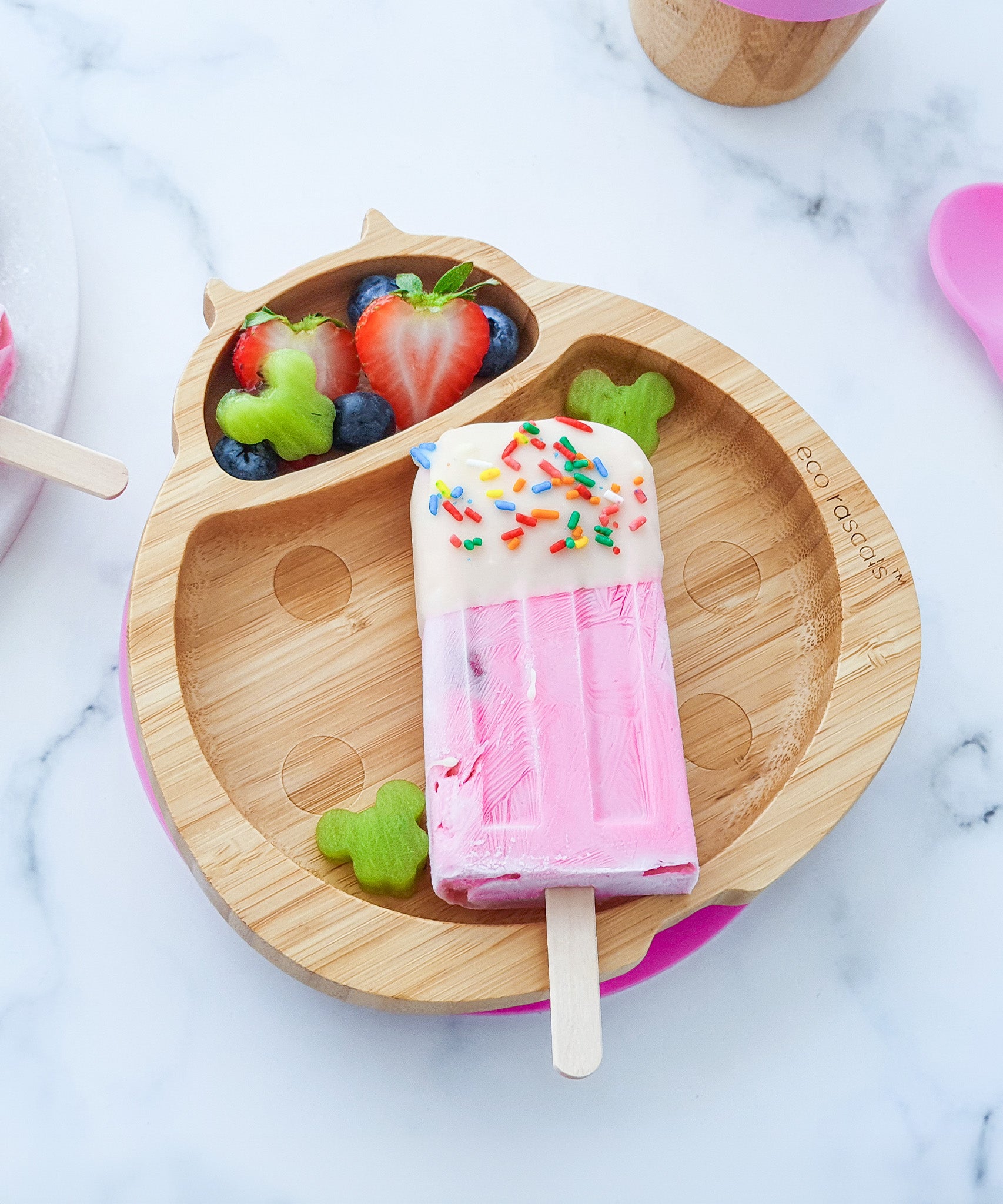 Eco Rascals Ladybird Bamboo Suction Plate with a pink ice lolly and fresh fruit.