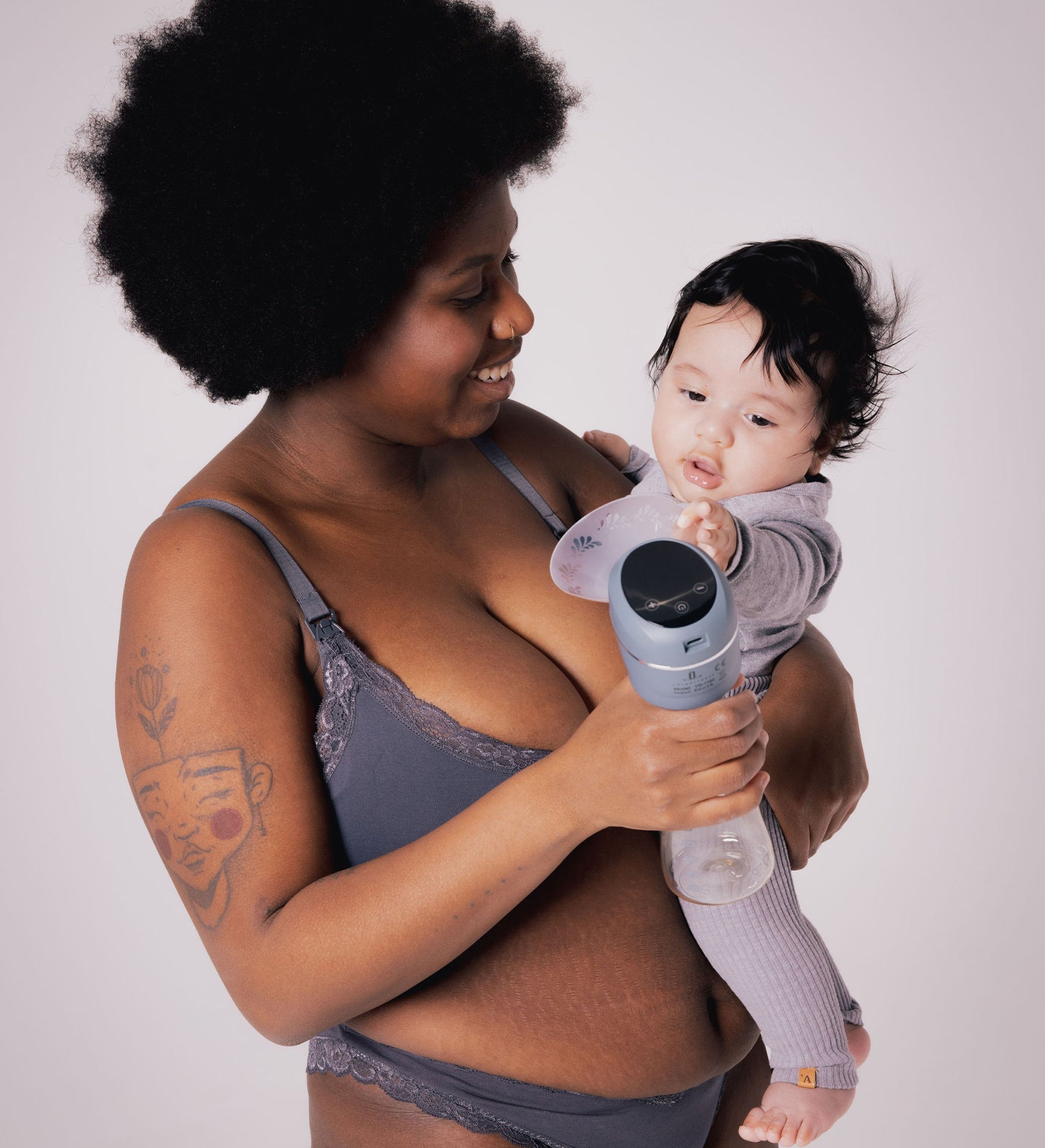 A parent holding their child, with the child reaching towards the Lola&Lykke Smart Electric Breast Pump