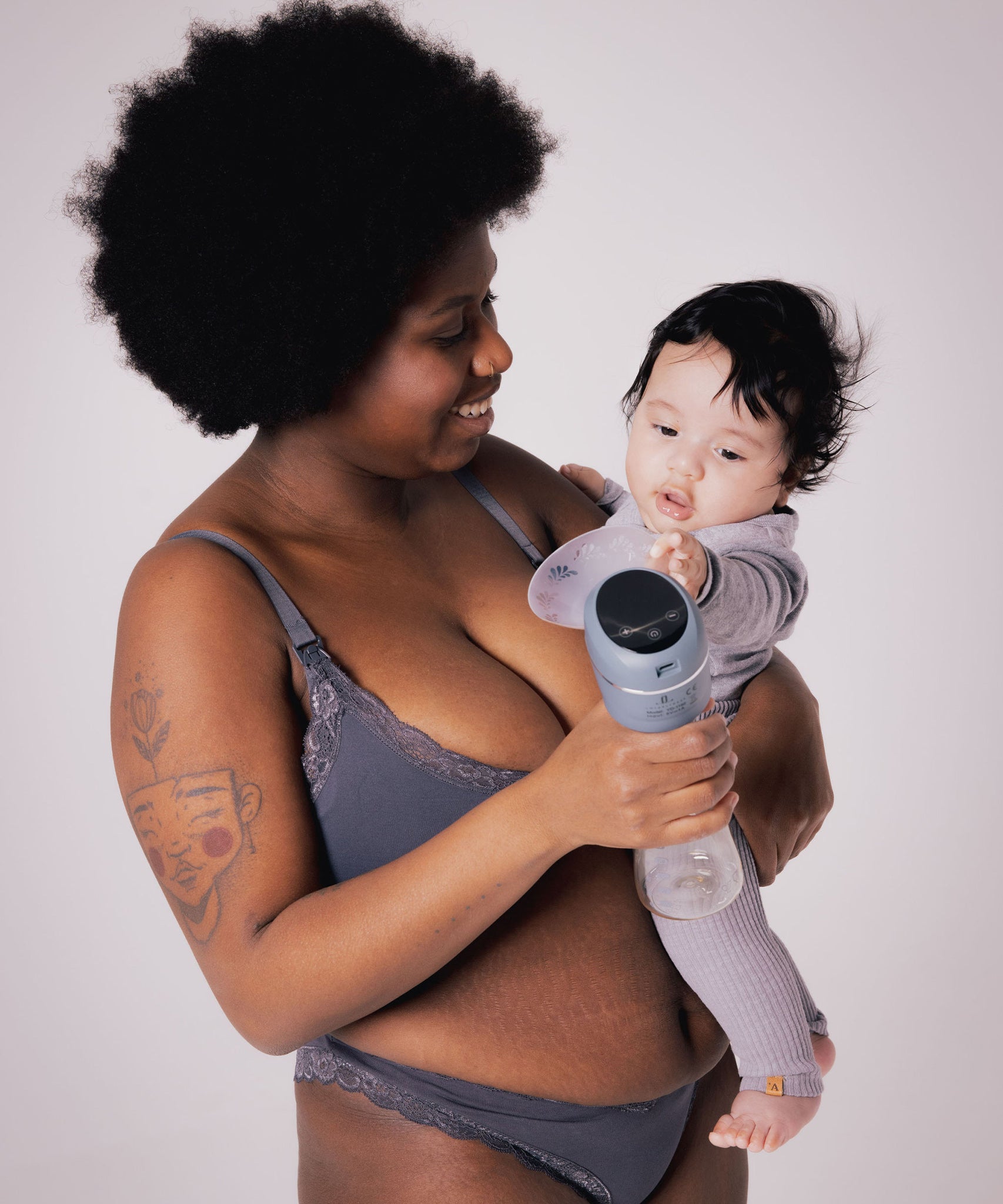 A parent holding their child, with the child reaching towards the Lola&Lykke Smart Electric Breast Pump