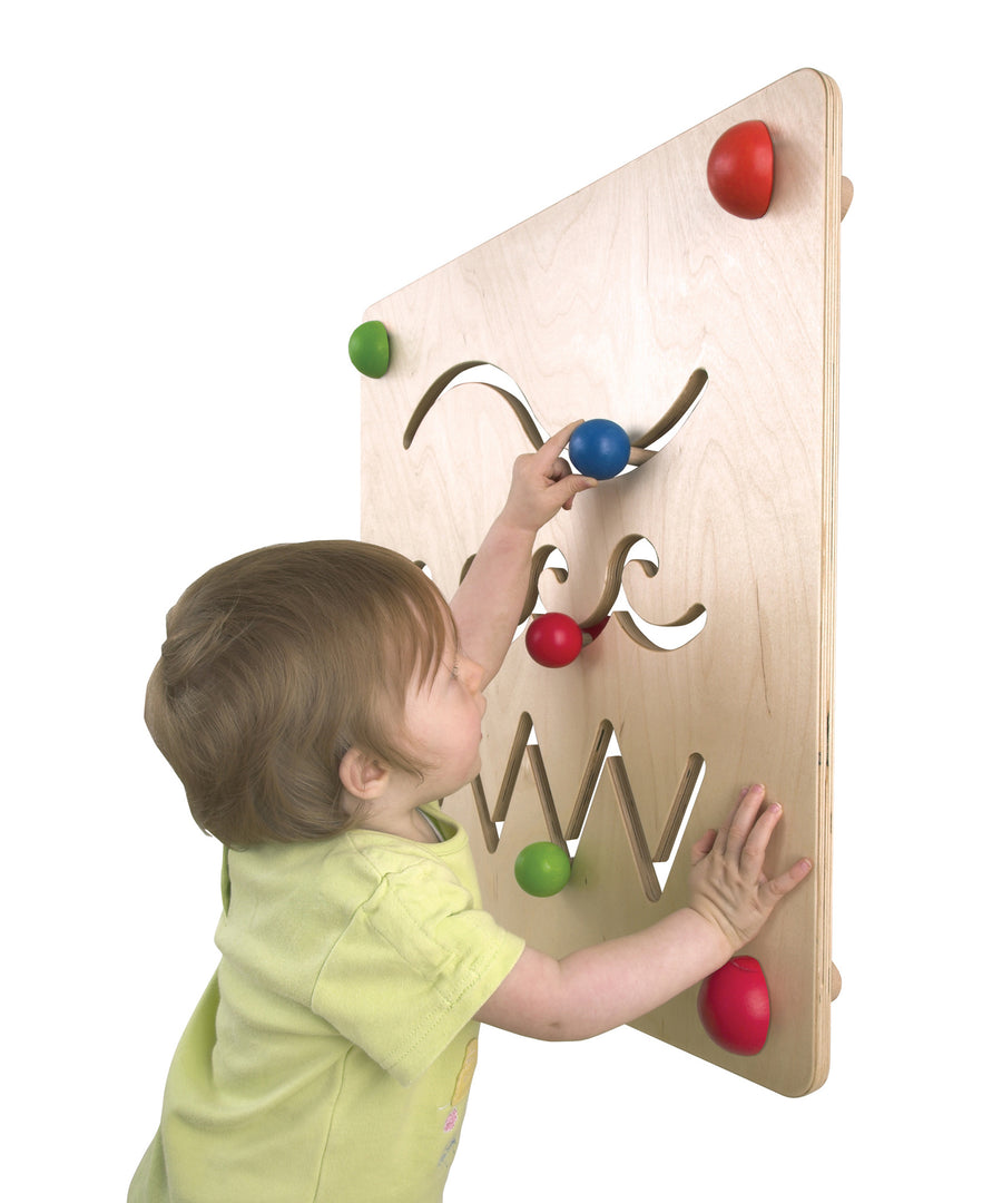 A child concentrating and moving the wooden part along the wavy maze path