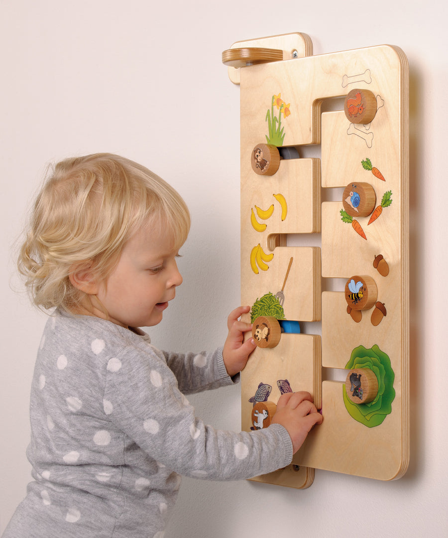 A child playing with the Erzi Baby Animal Wallboard Game. The image shows a child matching animals with their favourite food. A fantastic learning and play toy