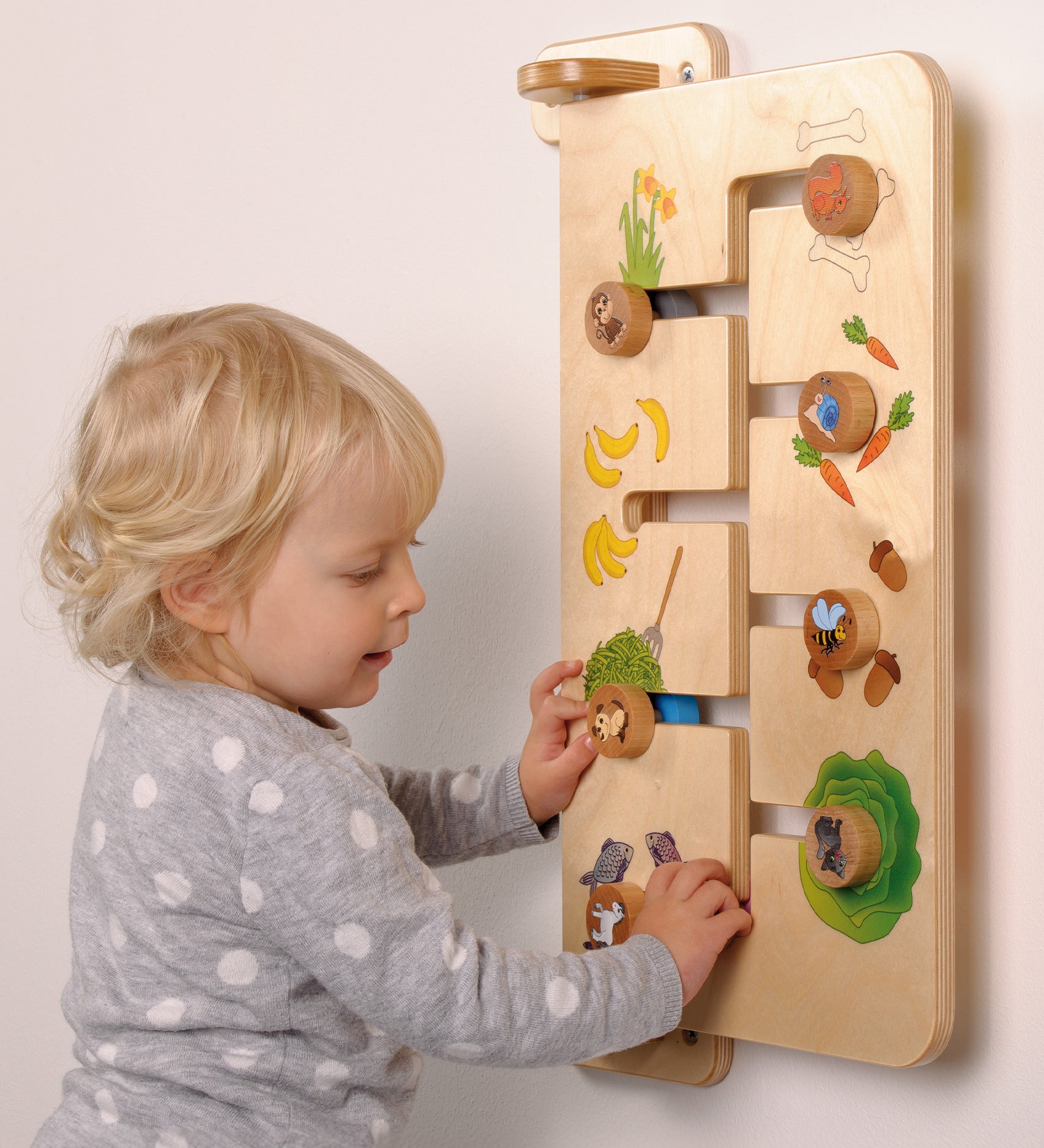 A child playing with the Erzi Baby Animal Wallboard Game. The image shows a child matching animals with their favourite food. A fantastic learning and play toy