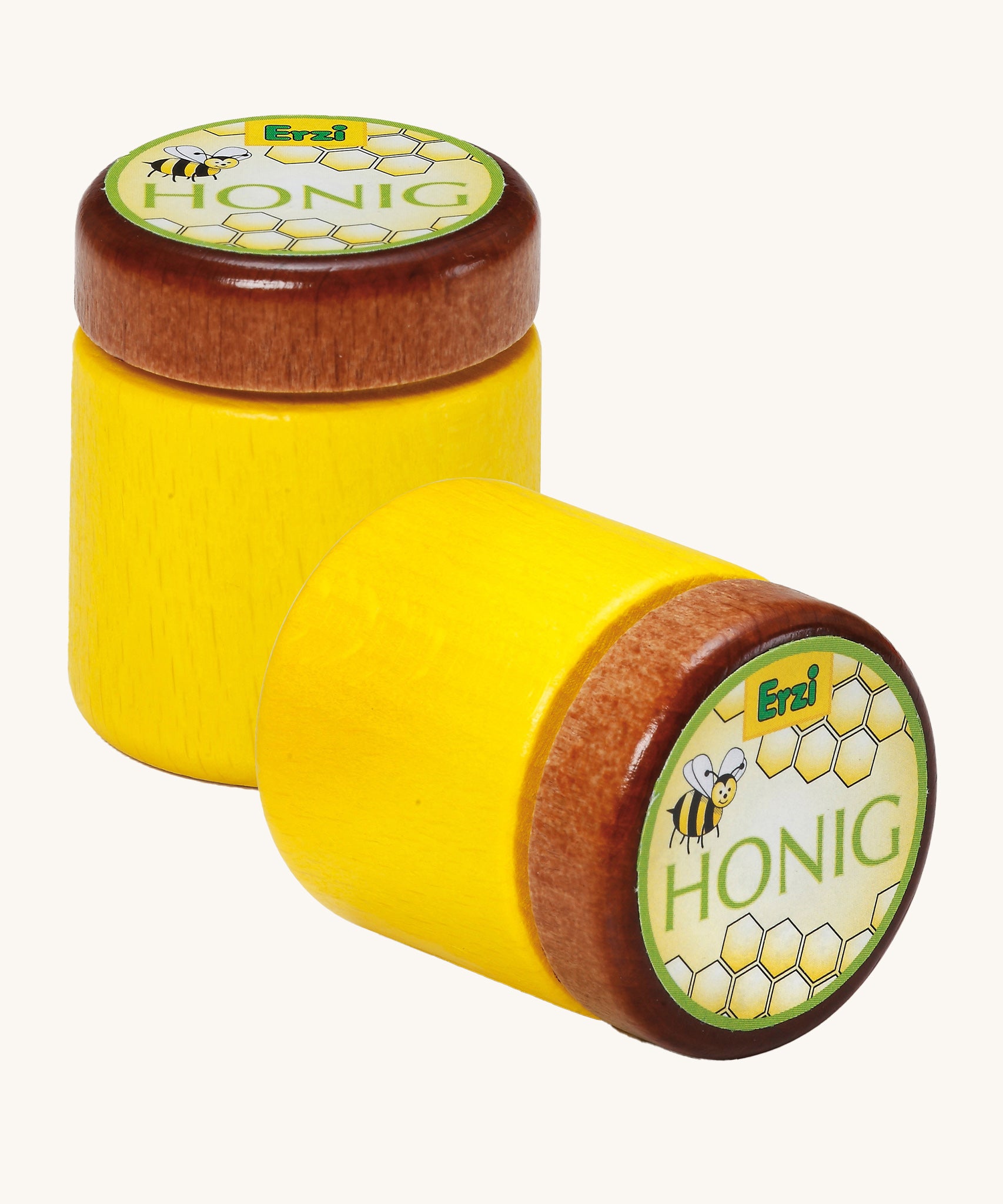 Two Erzi Wooden Honey Jar, one stood up and one laying down, on a cream background