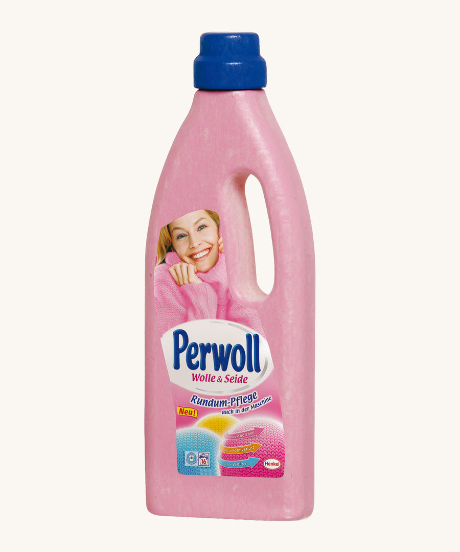 Erzi Wooden Delicates Laundry Detergent, in a pink bottle with a blue lid, and a colourful graphic. On a cream background