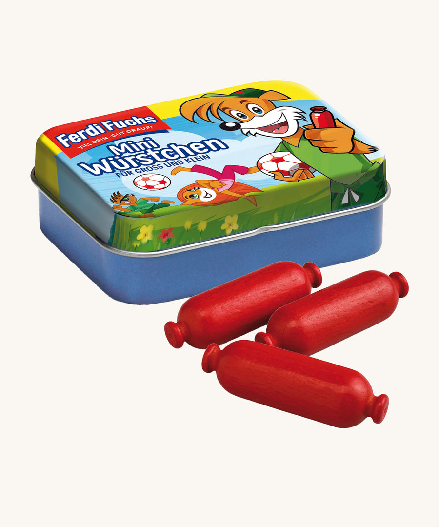 Erzi Wooden Mini Sausages In A Tin. 3 mini wooden sausages in a dark red colour are placed in front of a colourful mini sausages tin. On a cream background