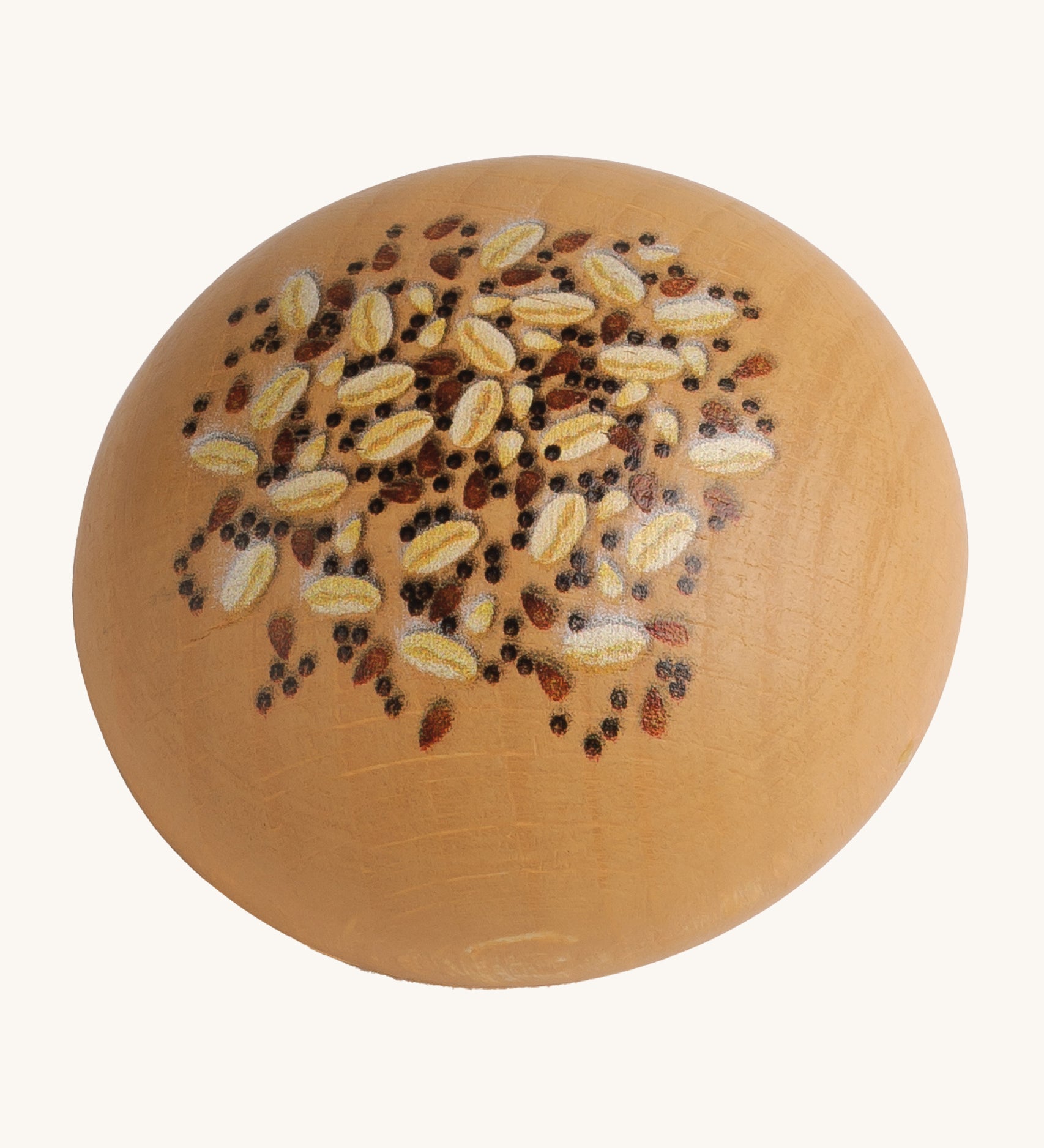 Erzi Wooden Seed Roll. A light brown wooden bread roll, with painted seeds and grains on top. On a cream background