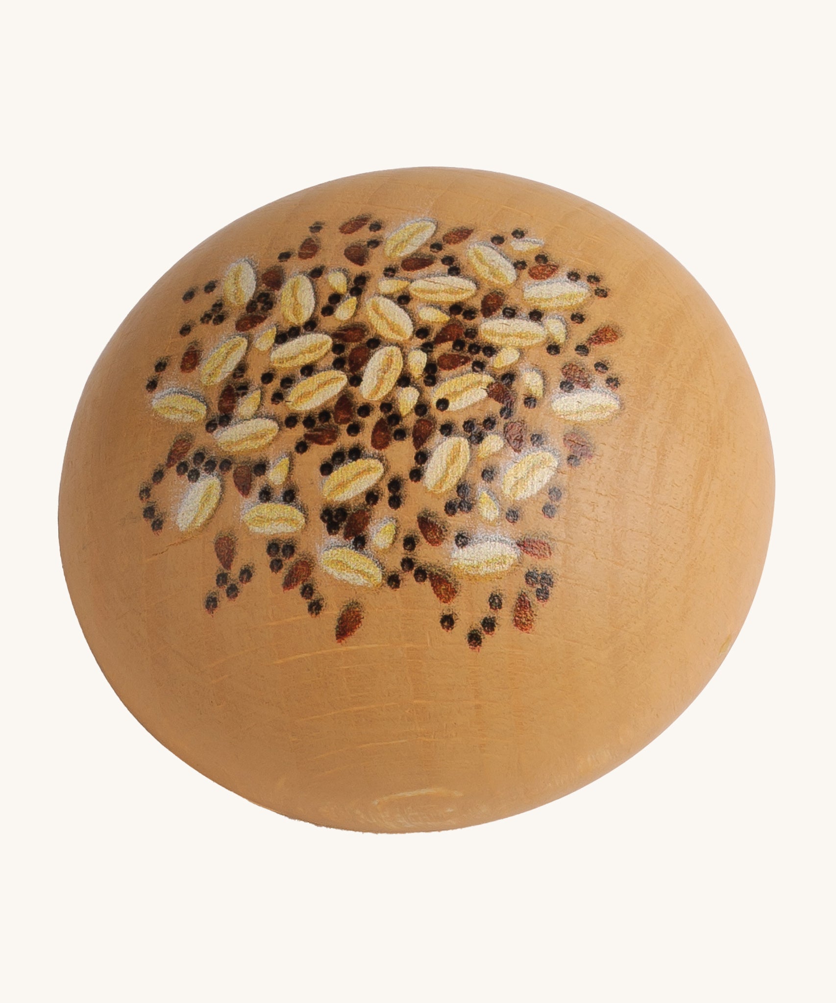 Erzi Wooden Seed Roll. A light brown wooden bread roll, with painted seeds and grains on top. On a cream background