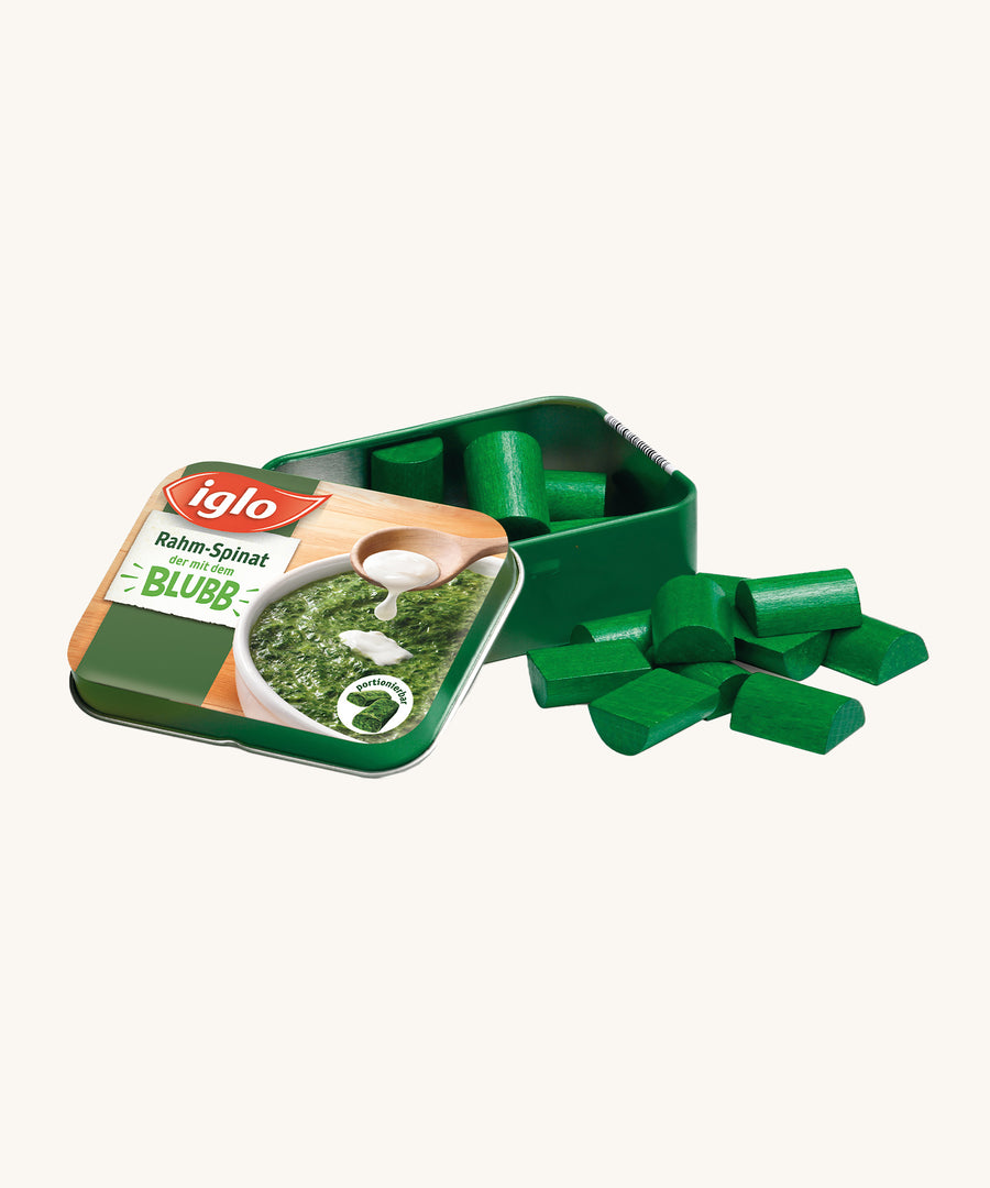 Erzi Wooden Spinach In A Tin, on a cream background. Green wooden spinach pieces with a metal tin which has a photo of real spinach on the front