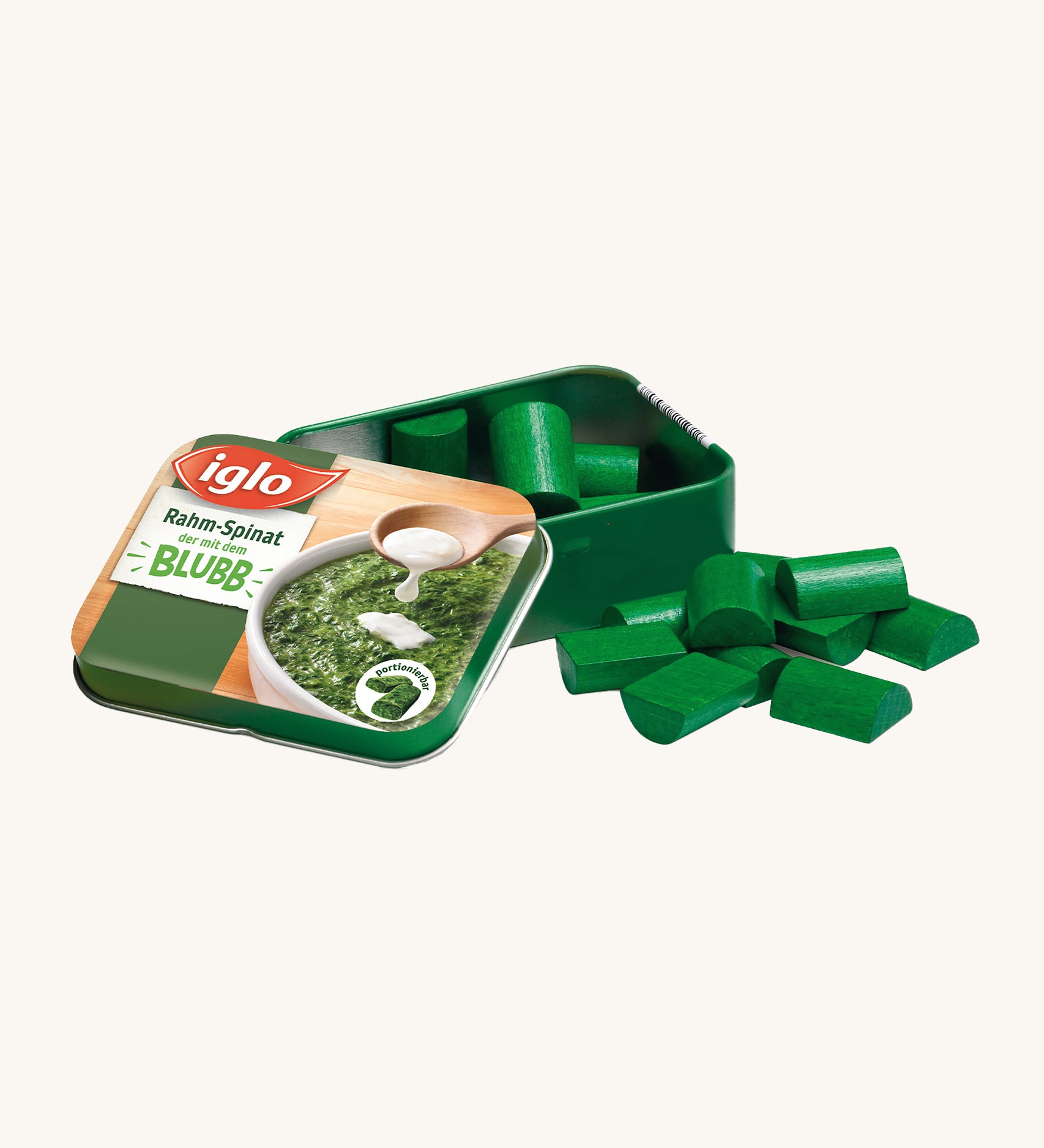 Erzi Wooden Spinach In A Tin, on a cream background. Green wooden spinach pieces with a metal tin which has a photo of real spinach on the front