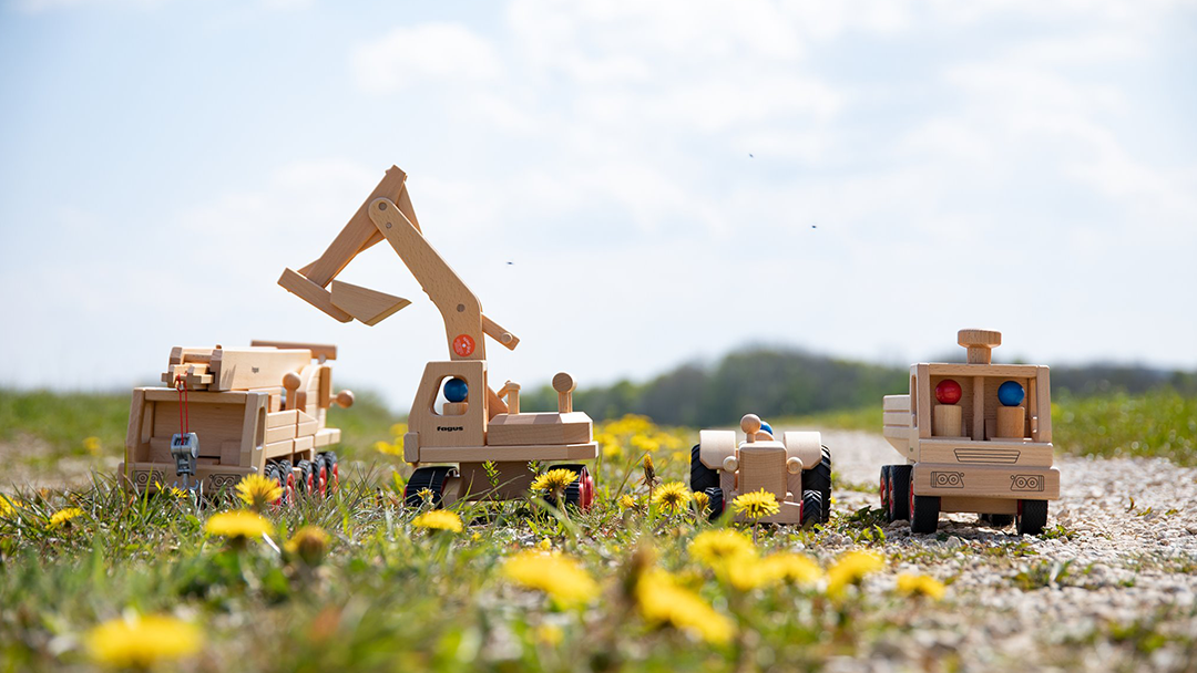 Fagus wooden toy vehicles in a field