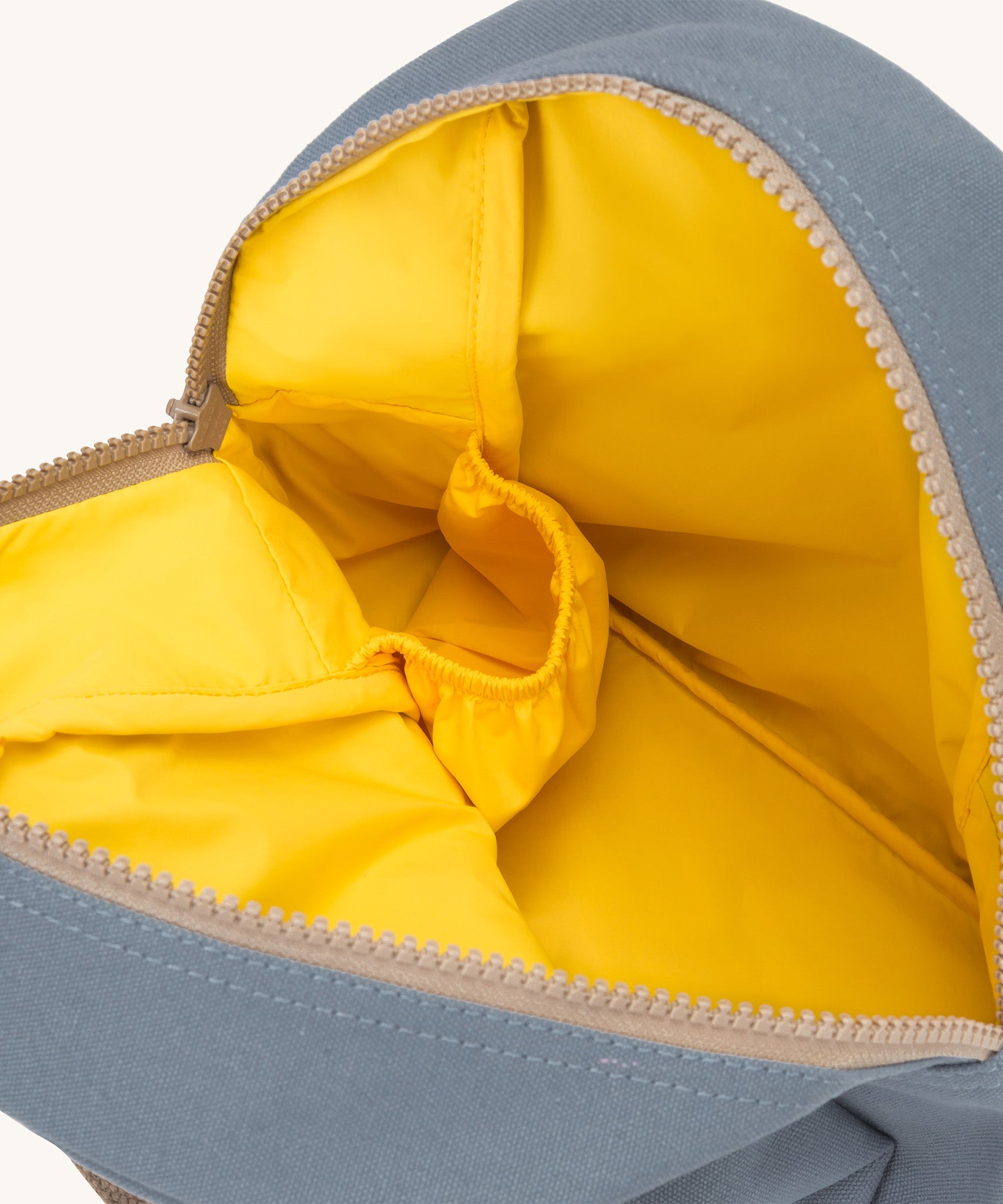 Fluf zip lunch bag in a light  blue colour with a yellow inner lining and a light brown zip.