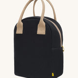 Fluf zip lunch bag in a solid black colour with a light brown handle and light brown zip detail on a cream background.